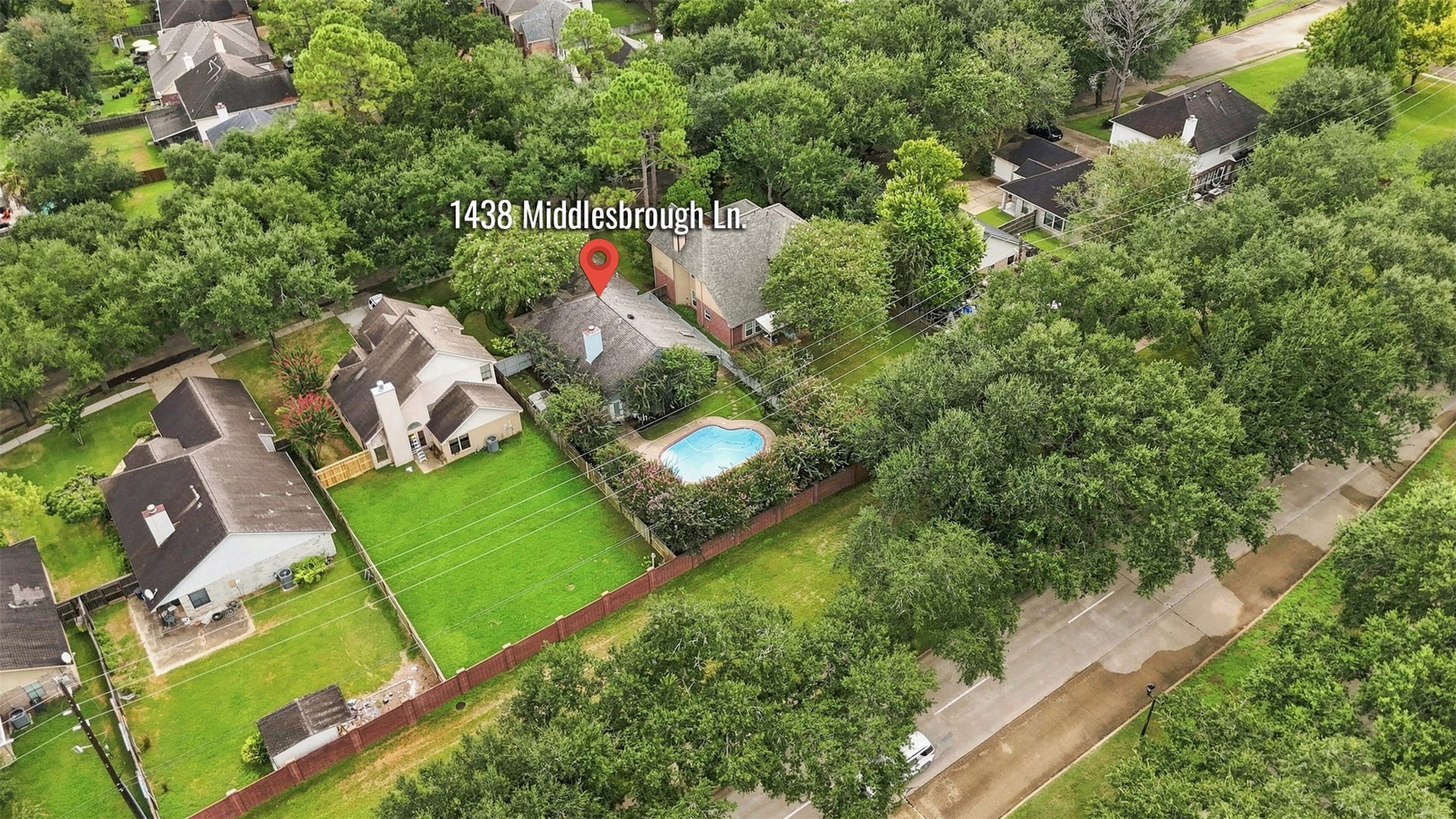 Aerial view showcases the homes setting within an established, tree-lined neighborhood and highlights the private backyard with in-ground pool.