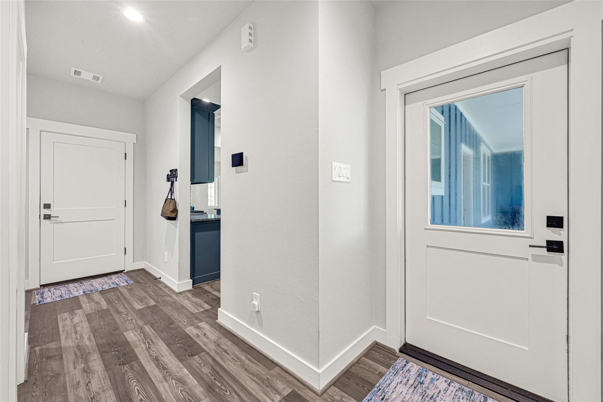 3325 County Road 160, Alvin, TX 77511 Hallway with access to garage, patio, laundry, half bath, and primary suite