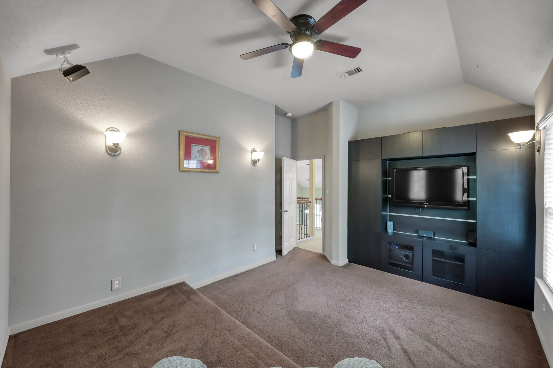 2502 Wynden Meadow Lane, Conroe, TX 77304 Dedicated media room with built-in entertainment center and elevated seating platform, perfect for movie nights, gaming, or relaxing with family and friends.