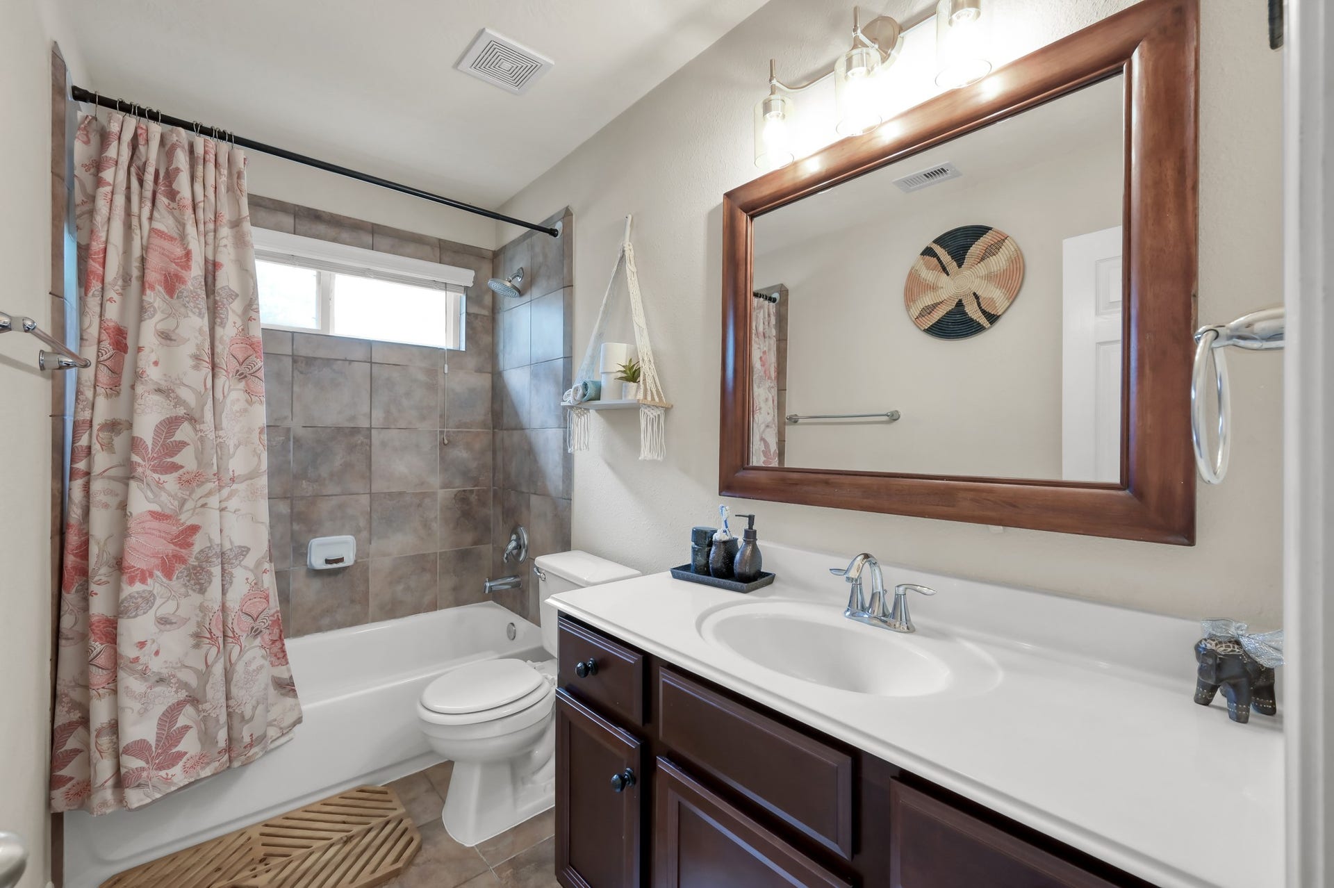 2502 Wynden Meadow Lane, Conroe, TX 77304 Beautiful full bath featuring tiled shower surround, oversized mirror, updated lighting, and plenty of counter space for everyday convenience.