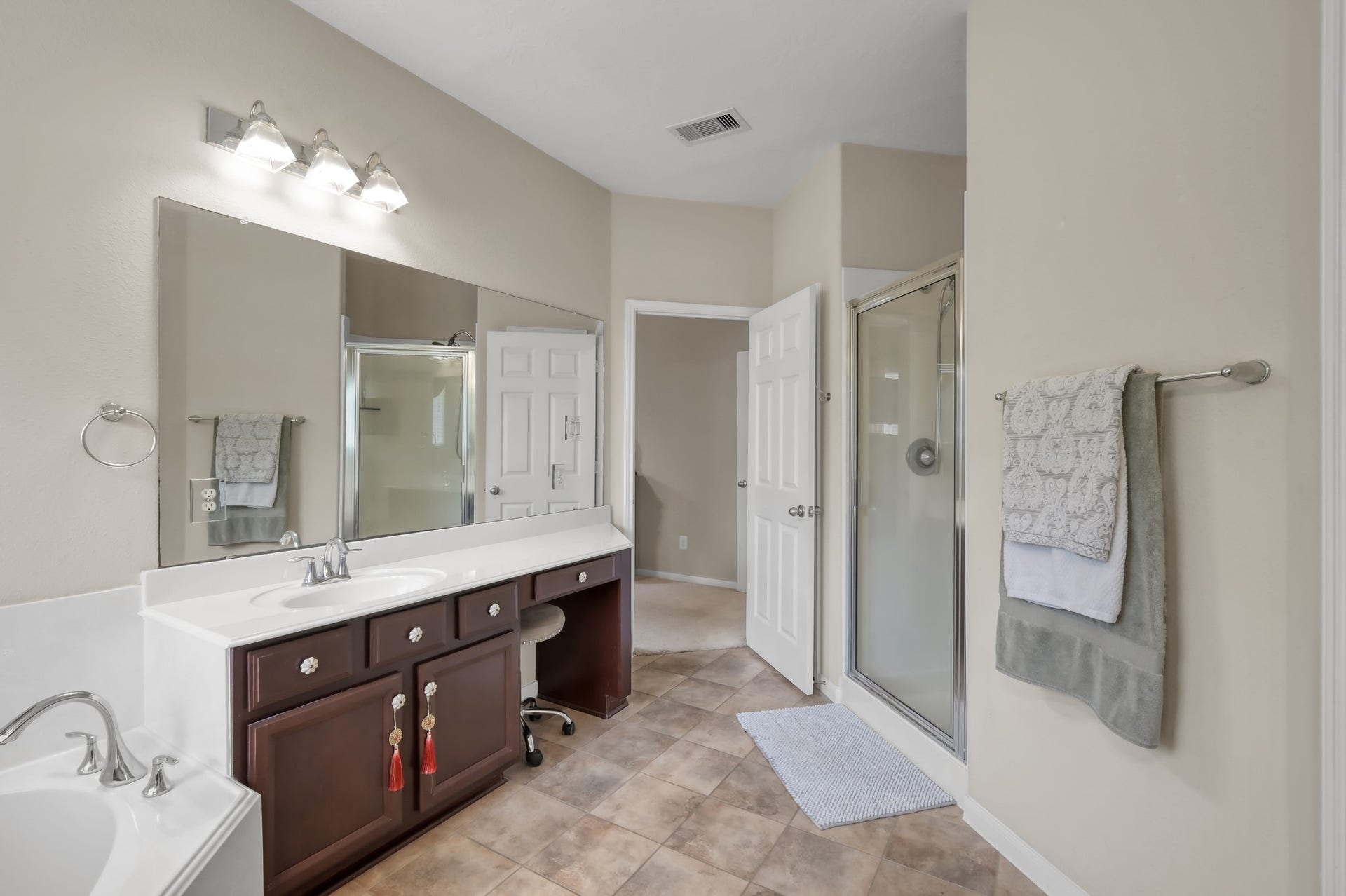 2502 Wynden Meadow Lane, Conroe, TX 77304 Well-appointed primary bath with dual vanities, ample counter space, and a separate glass-enclosed shower. Functional layout with plenty of storage and natural light.