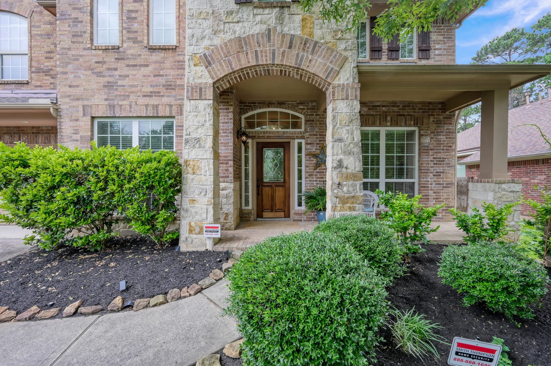 2502 Wynden Meadow Lane, Conroe, TX 77304 The covered front porch and impressive stone archway create the perfect place to greet guests or enjoy a peaceful morning coffee. Beautiful landscaping and custom front door details add to the homes charm.
