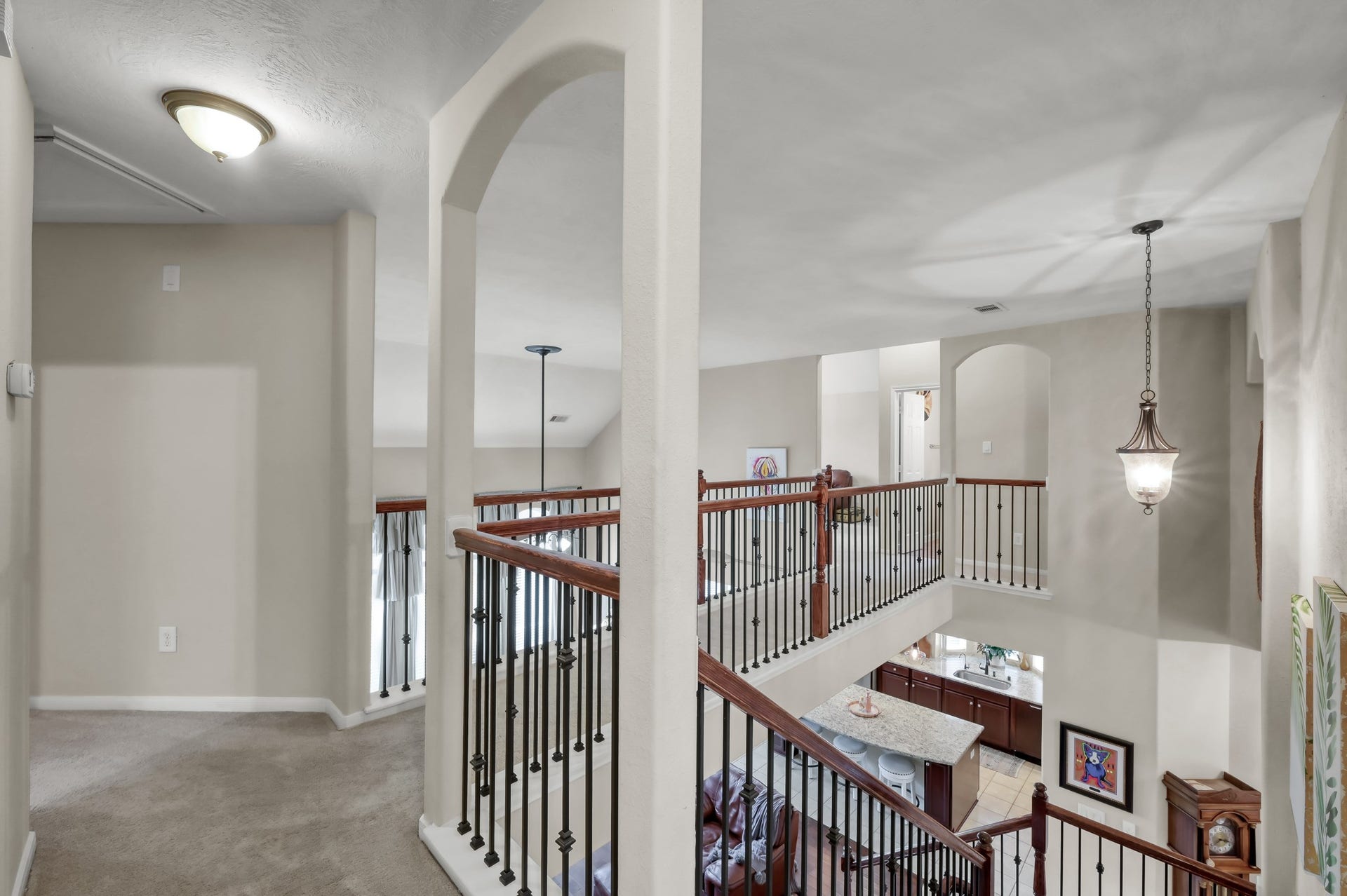 2502 Wynden Meadow Lane, Conroe, TX 77304 Beautiful open upstairs landing overlooking the main living area below, featuring elegant iron railing details and plenty of space for a reading nook or flex area.