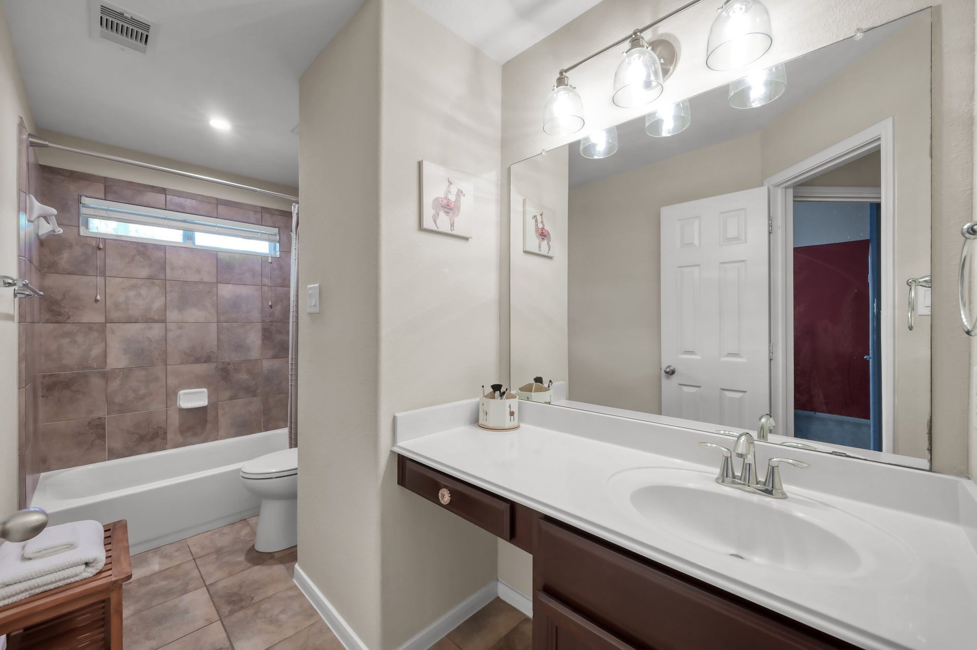 2502 Wynden Meadow Lane, Conroe, TX 77304 Bright and clean full bathroom with large vanity, generous mirror space, and tiled tub/shower combo.