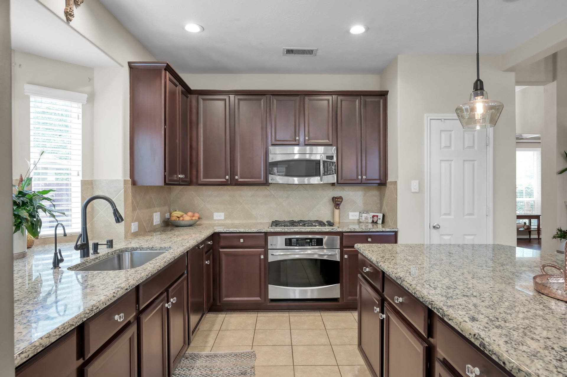 2502 Wynden Meadow Lane, Conroe, TX 77304 Beautiful granite countertops, rich cabinetry, stainless steel appliances, and plenty of prep space make this kitchen both stylish and functional. A perfect setup for everyday cooking and hosting guests.