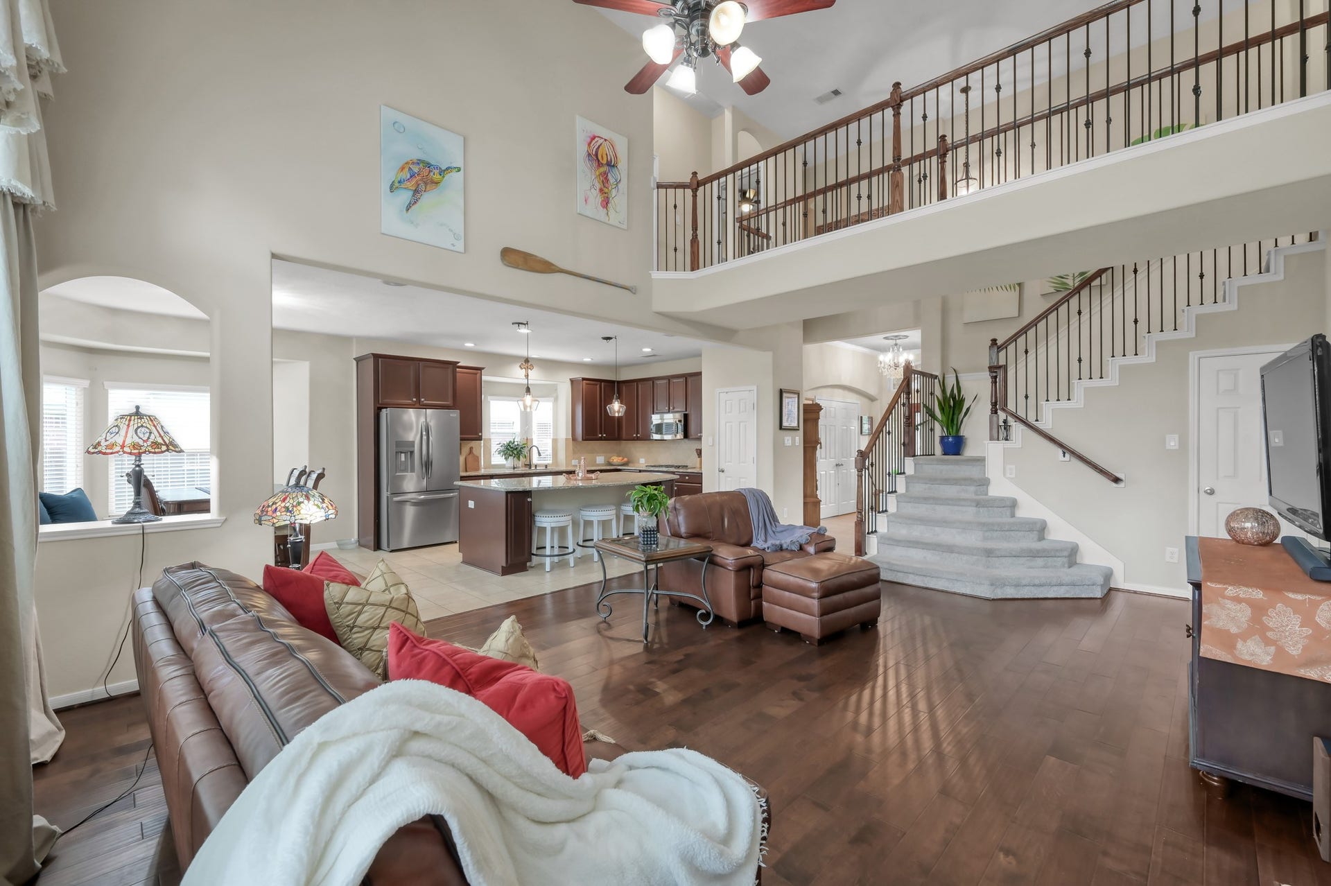 2502 Wynden Meadow Lane, Conroe, TX 77304 This stunning main living room also features dramatic two-story ceilings, elegant staircase details, and an open layout that creates a bright and welcoming atmosphere throughout the home.