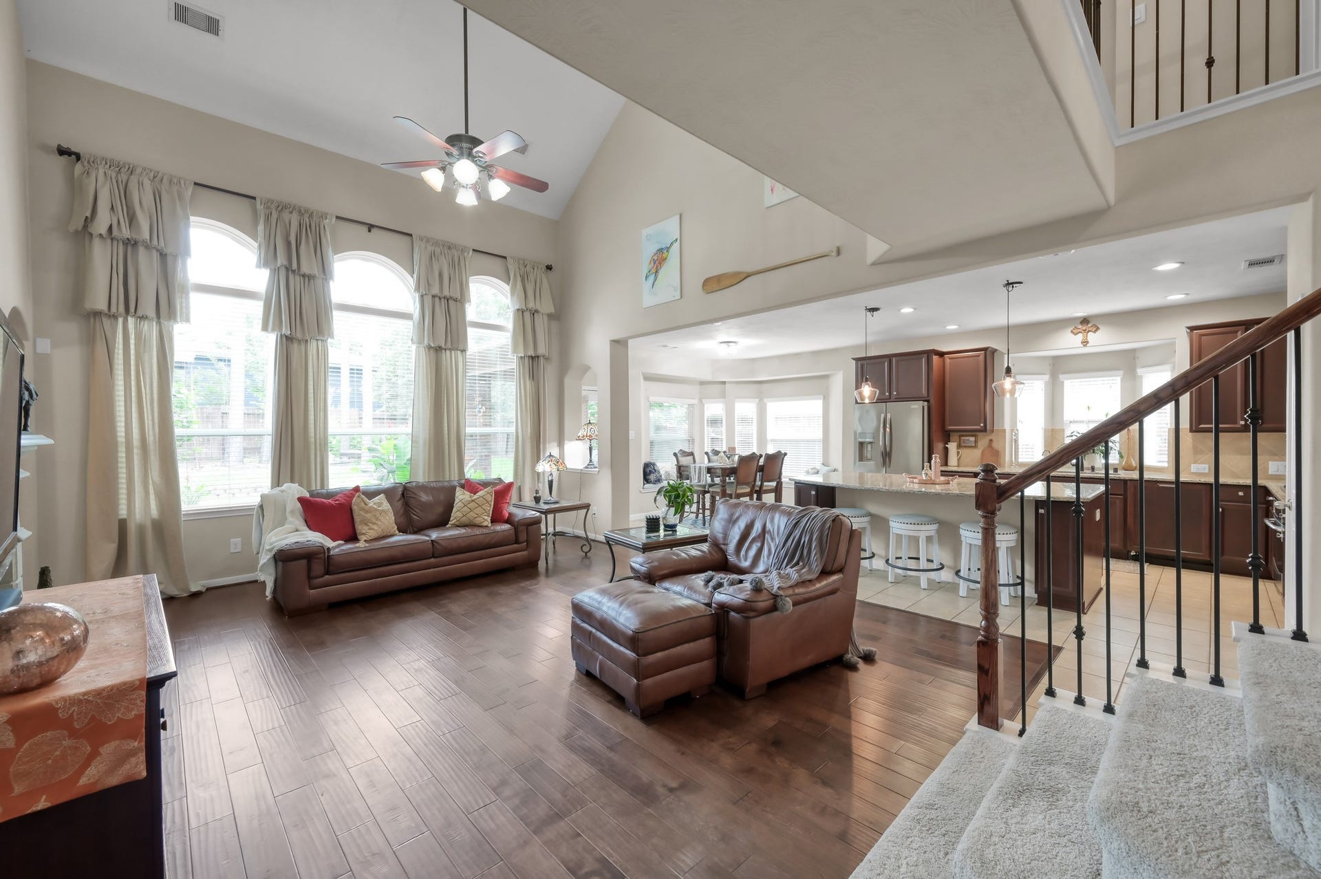 2502 Wynden Meadow Lane, Conroe, TX 77304 Spacious open-concept living area with soaring ceilings, beautiful wood floors, and oversized windows that fill the home with natural light. Perfect for everyday living and entertaining with an easy flow into the kitchen and breakfast area.