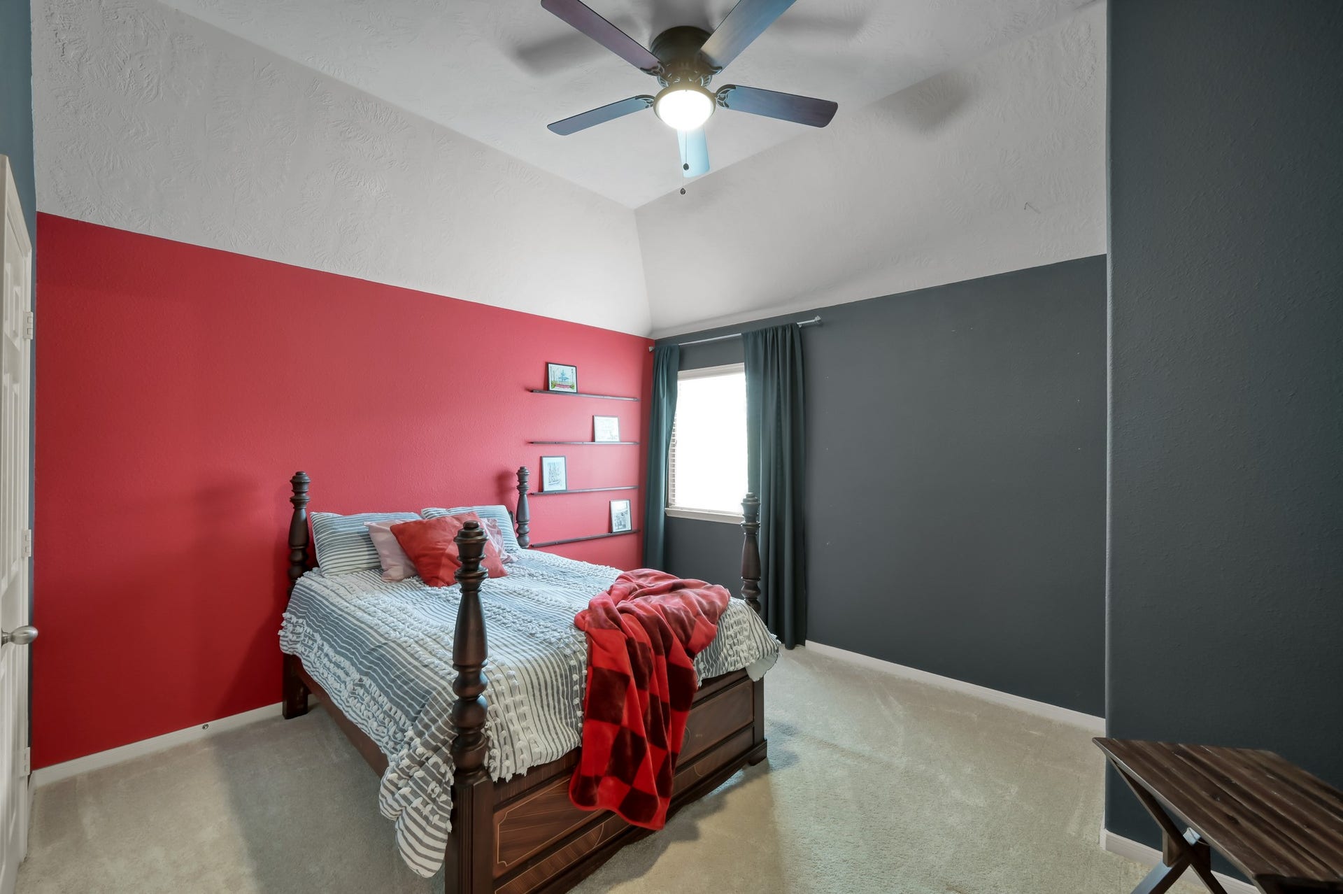 2502 Wynden Meadow Lane, Conroe, TX 77304 Stylish bedroom with vaulted ceilings, bold designer-inspired accent walls, and a cozy layout filled with natural light.