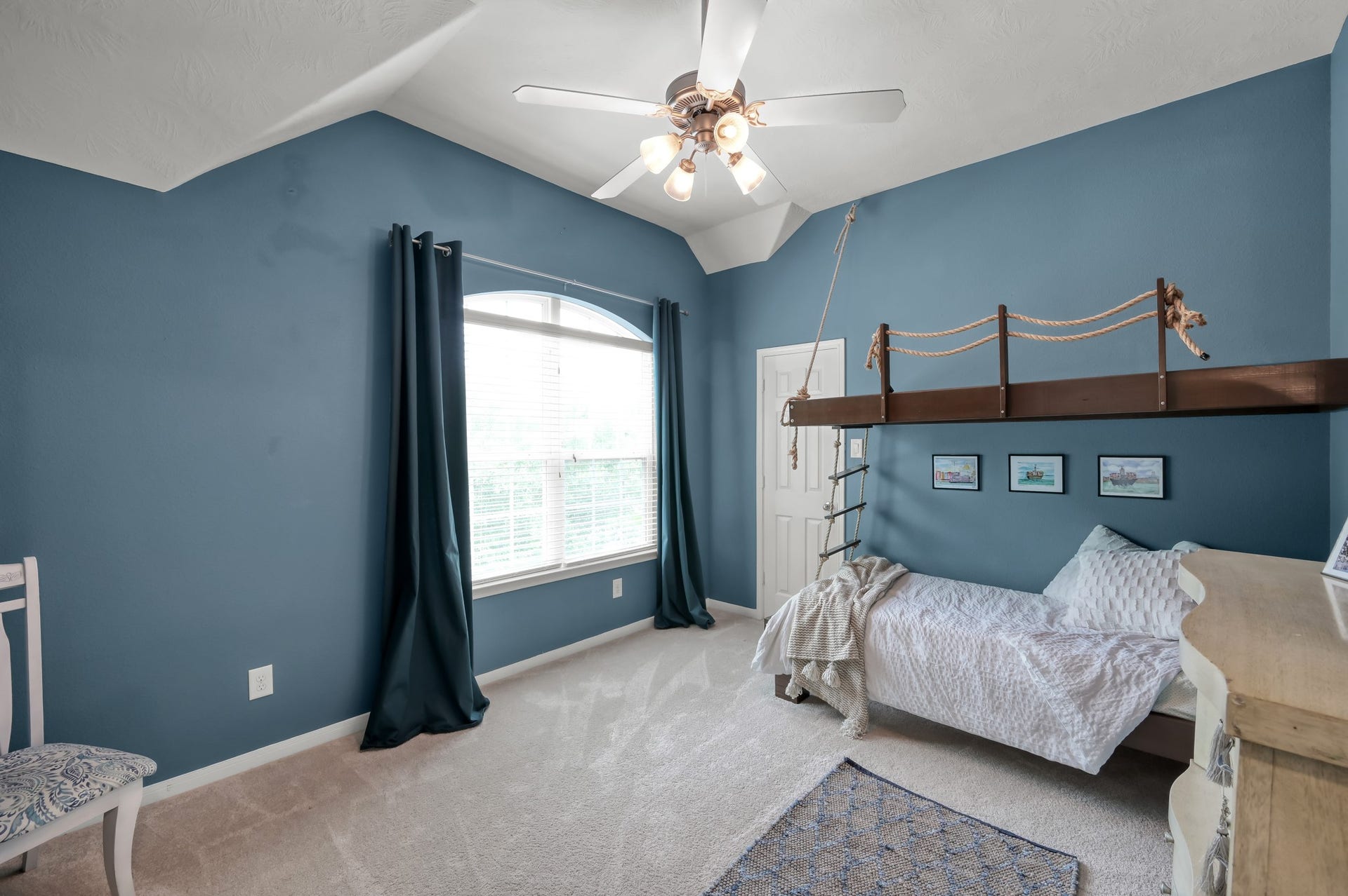 2502 Wynden Meadow Lane, Conroe, TX 77304 Bright and spacious bedroom featuring vaulted ceilings, large windows for natural light, and unique built-in custom bunk bed details that add character and charm.