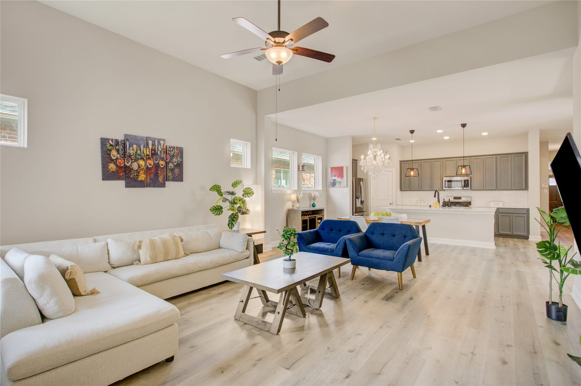 3423 Tranquil Harvest Trail, Richmond, TX 77406 Expansive family room flowing into the kitchen, showcasing spacious seating area, large island with breakfast bar, cabinetry, and stainless steel appliances.