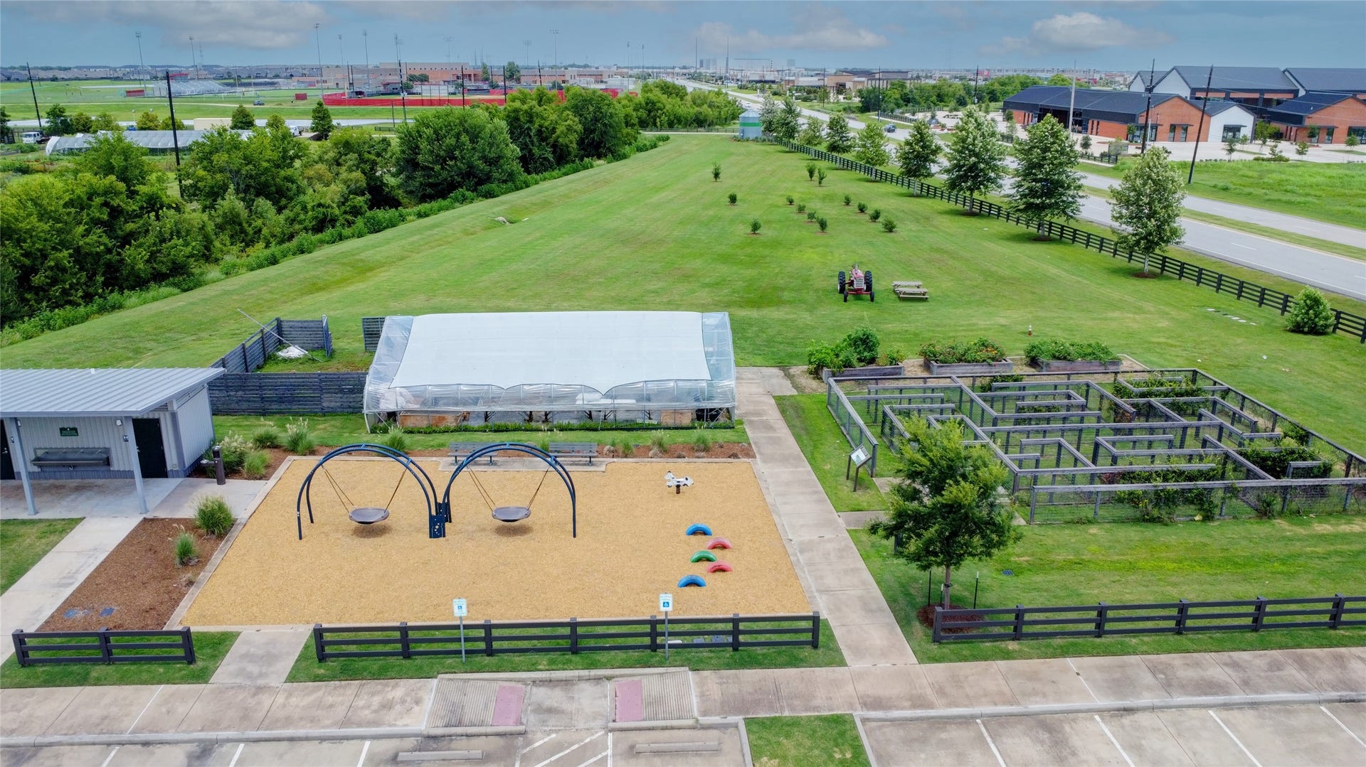3423 Tranquil Harvest Trail, Richmond, TX 77406 Aerial view of the community showing a playground, greenhouse, garden plots, landscaped open space, walking paths, and nearby community facilities.
