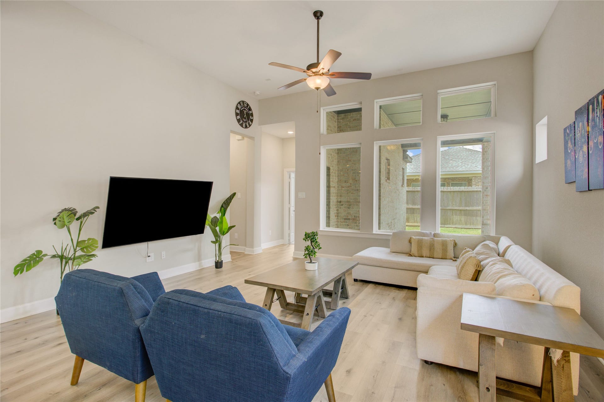 3423 Tranquil Harvest Trail, Richmond, TX 77406 Bright family room featuring an open layout, ceiling fan, large windows, wide plank flooring, and a spacious seating area.