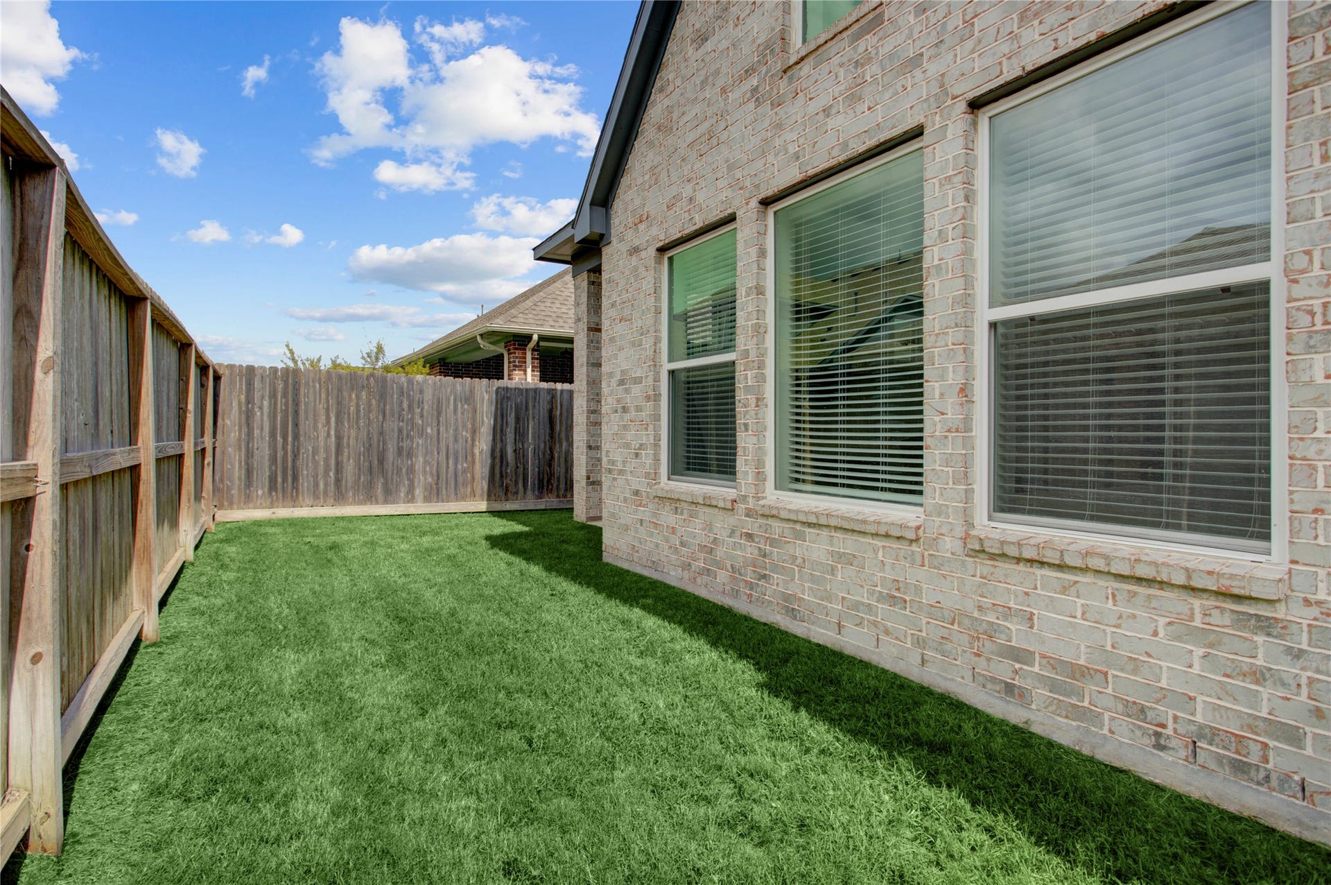 3423 Tranquil Harvest Trail, Richmond, TX 77406 Side yard with a grassy area, wood fencing, all brick exterior.