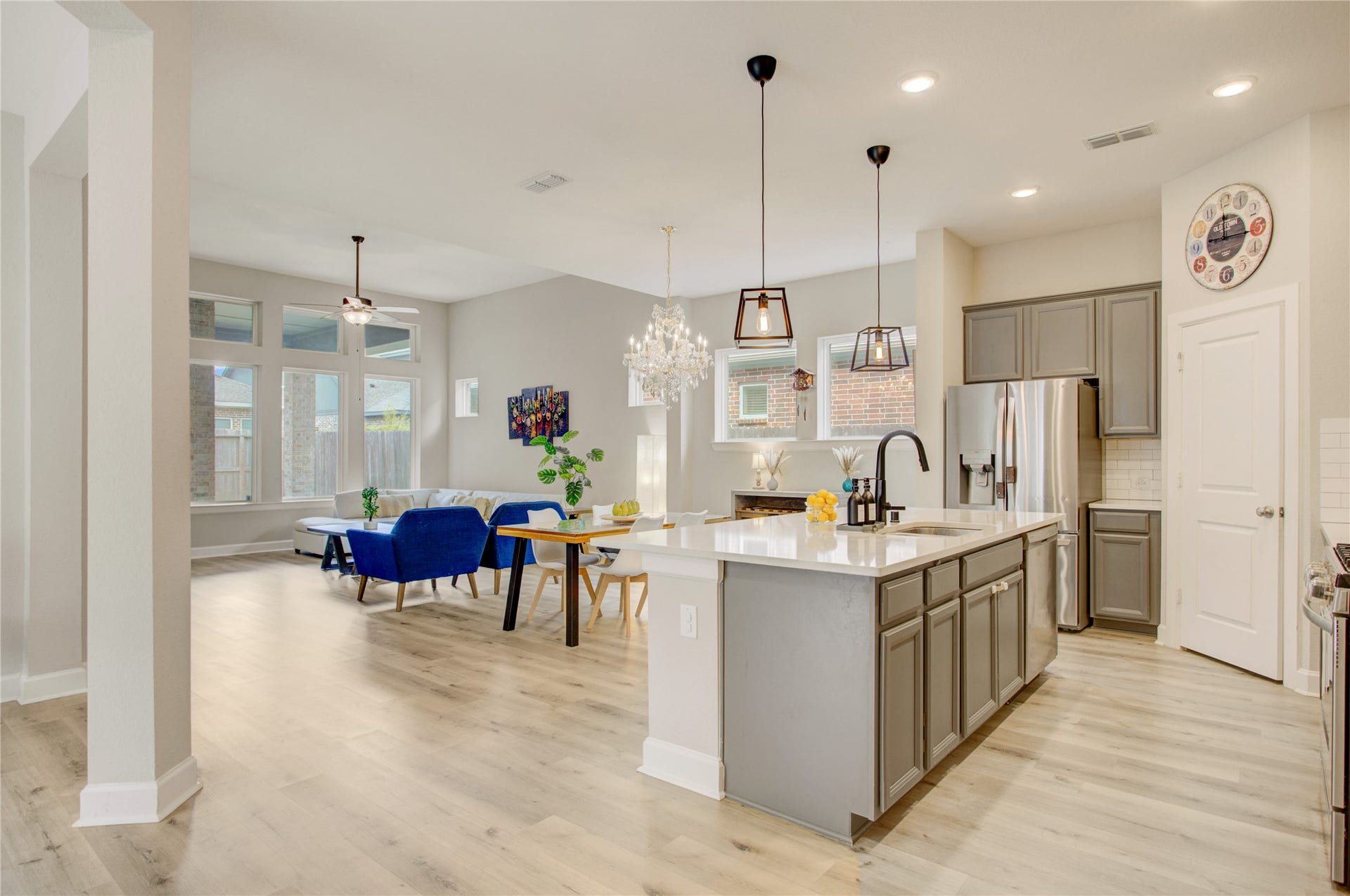3423 Tranquil Harvest Trail, Richmond, TX 77406 Well-appointed kitchen showcasing quartz countertops, a large island with breakfast bar, sophisticated cabinetry, pendant lighting, and an open connection to the dining and family areas.