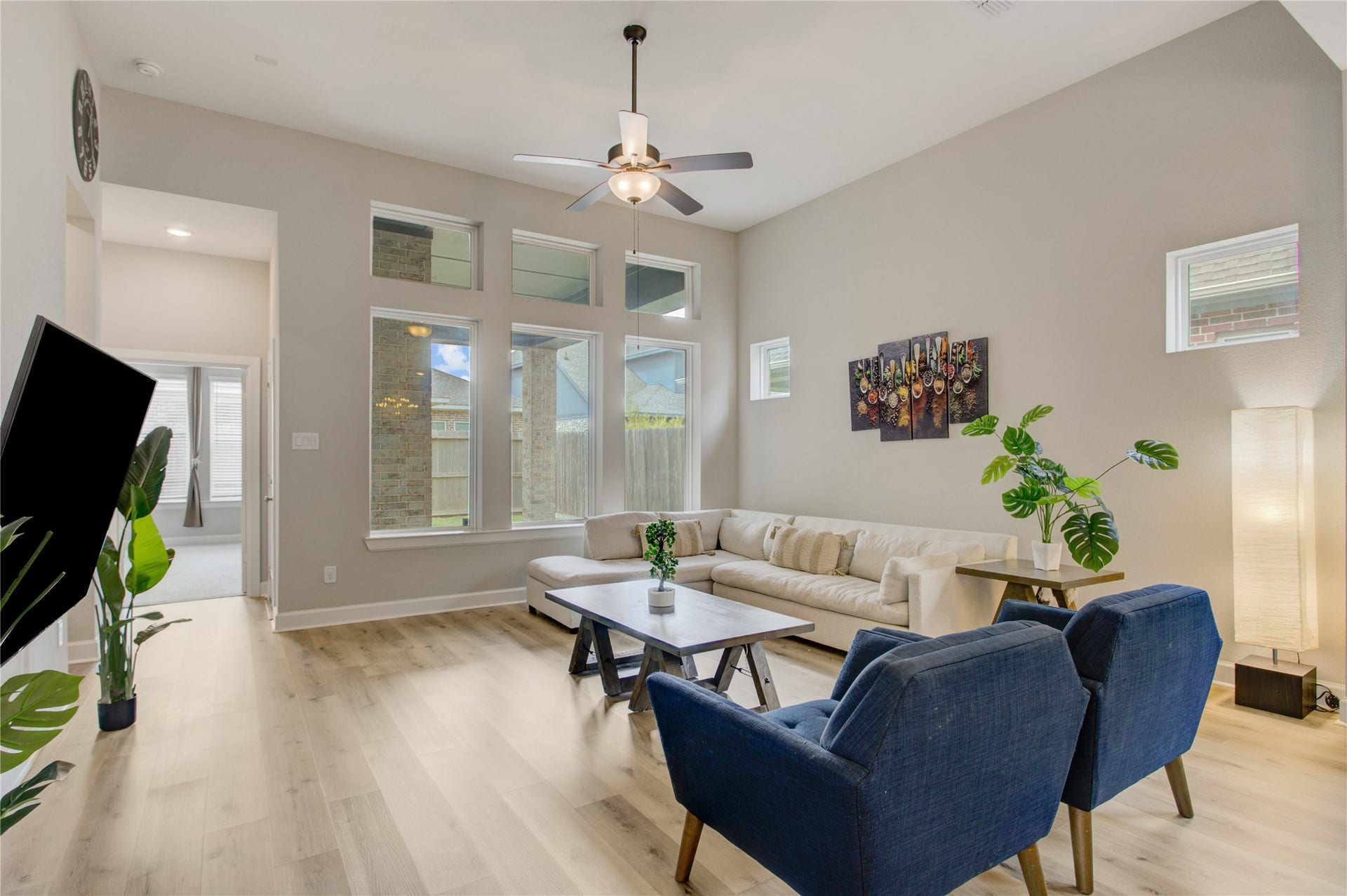3423 Tranquil Harvest Trail, Richmond, TX 77406 Airy family room highlighting expansive windows, and a generous seating area with an open view toward the adjoining room.