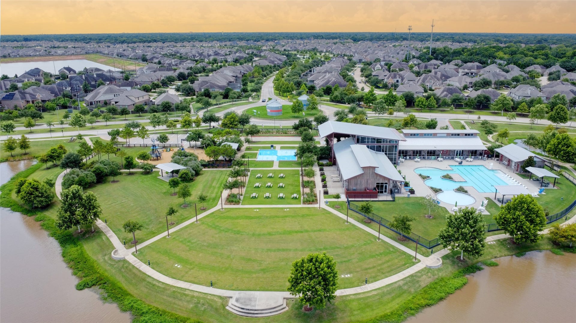 3423 Tranquil Harvest Trail, Richmond, TX 77406 Aerial view of the community amenity area featuring resort-style pools, a clubhouse, playground, landscaped green space, walking paths, and ponds.