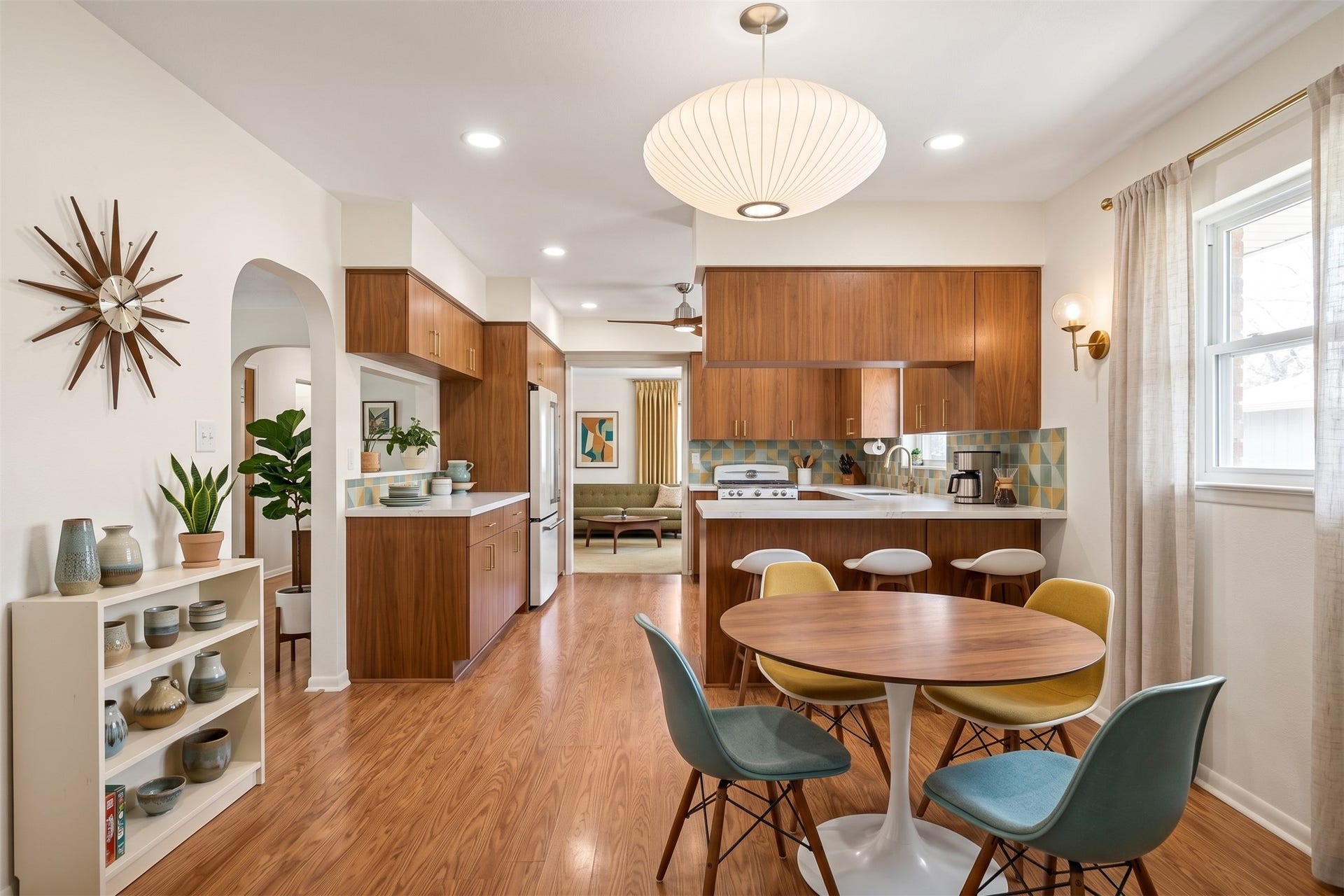 Modernized virtual kitchen featuring a large waterfall quartz island, matte white shaker cabinets with brushed gold hardware, and floor-to-ceiling subway tile. Includes integrated smart stainless steel appliances, recessed LED lighting, and statement  pendants.