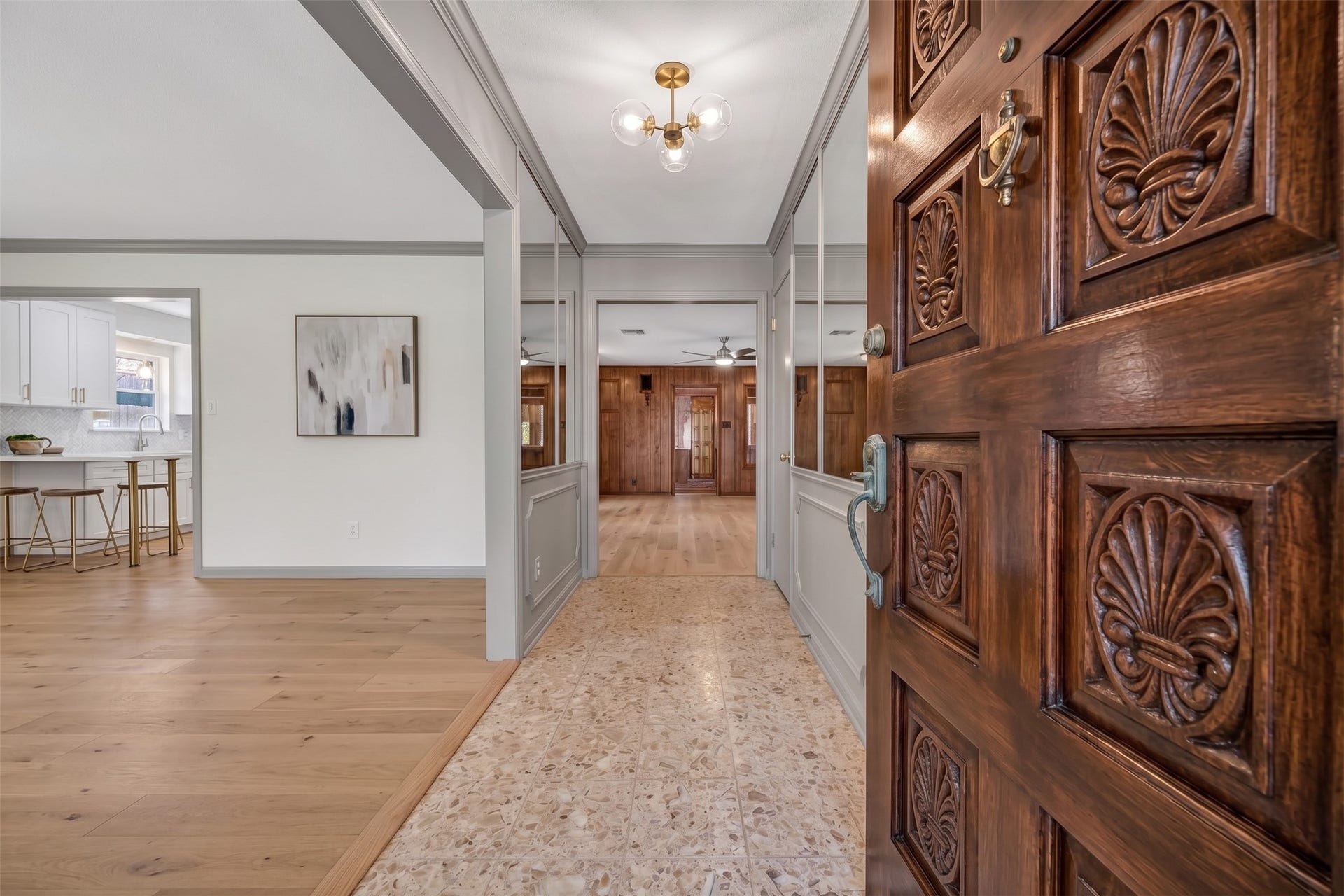 Keeping the original tile , Adding a fresh coat of stain to the original door & painting, changing light fixture,and removing the carpet. Transforms this entry to a mid century feel and keeping some of the original charm. Virtually enhanced.