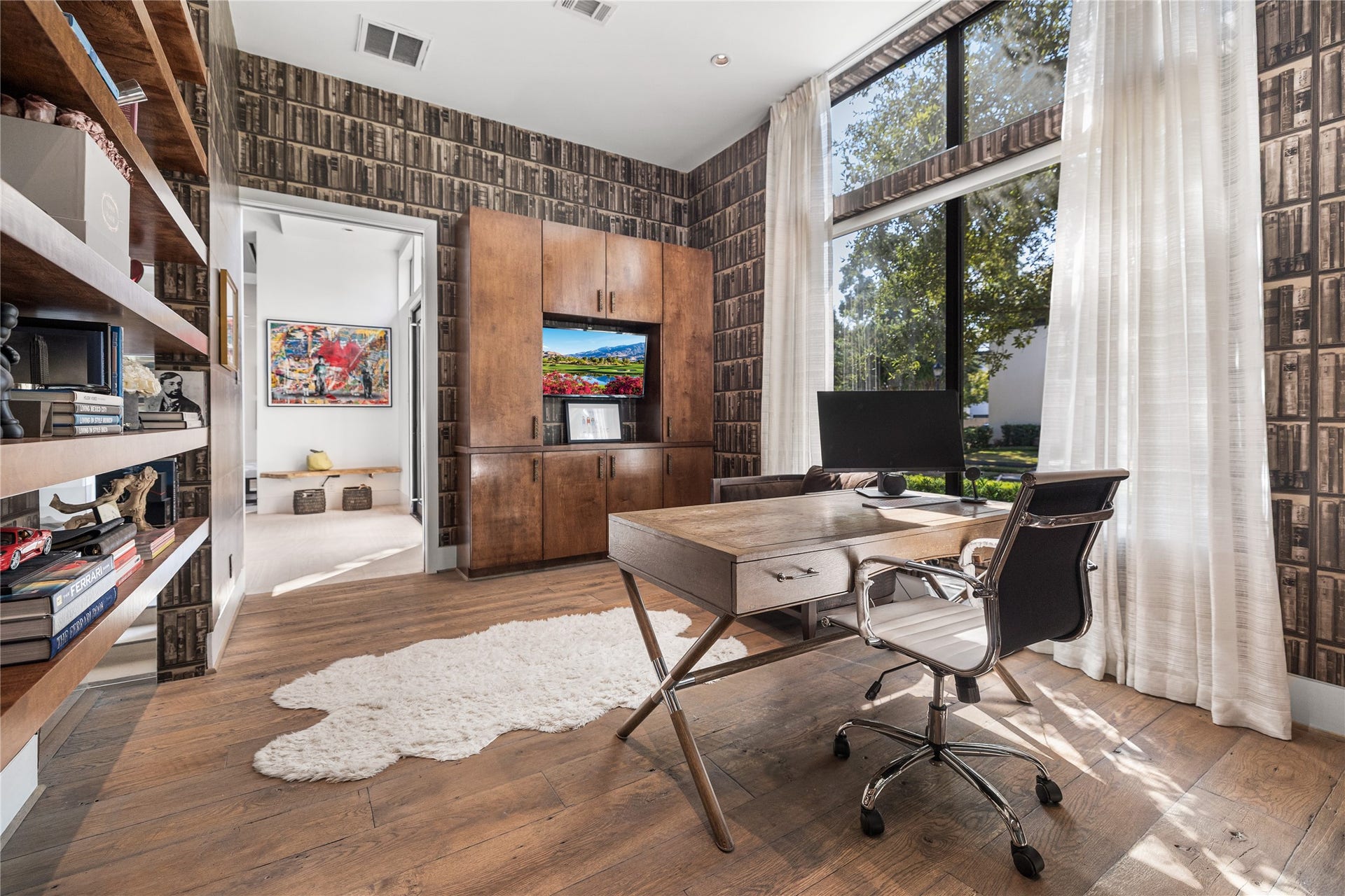 2608 Barbara Lane, Houston, TX 77005 This stately study opens directly to the foyer, offering a glimpse of the home's gracious flow, while floor-to-ceiling windows and warm built-in cabinetry complete the space.