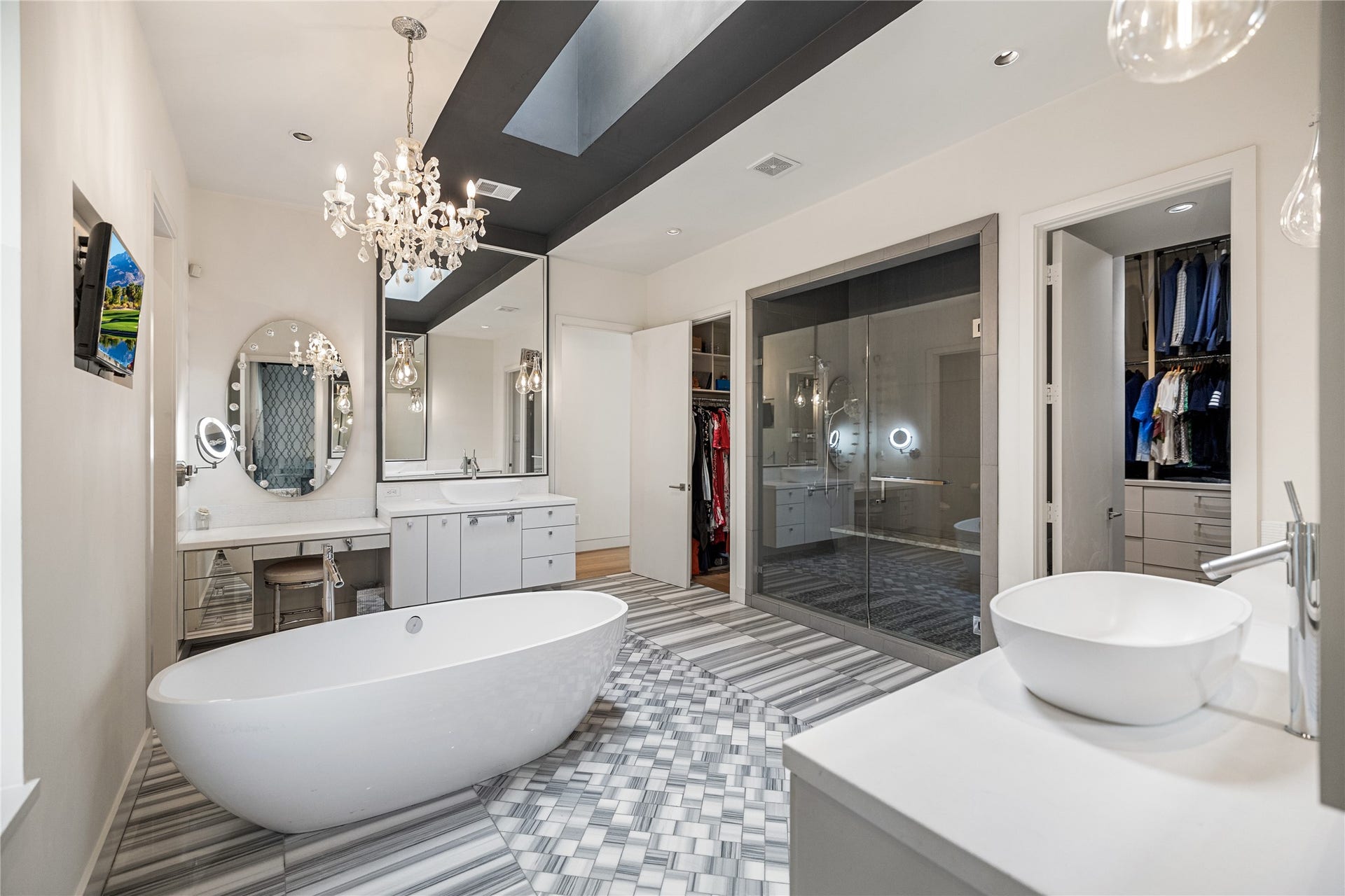 2608 Barbara Lane, Houston, TX 77005 This luxurious en-suite retreat is beautifully composed with dual vanities framed by expansive mirrors, a dedicated seated vanity and an oversized double-entry walk-in shower. This space flows seamlessly into a generous wrap-around walk-in closet, while the open door connects directly to the hallway.