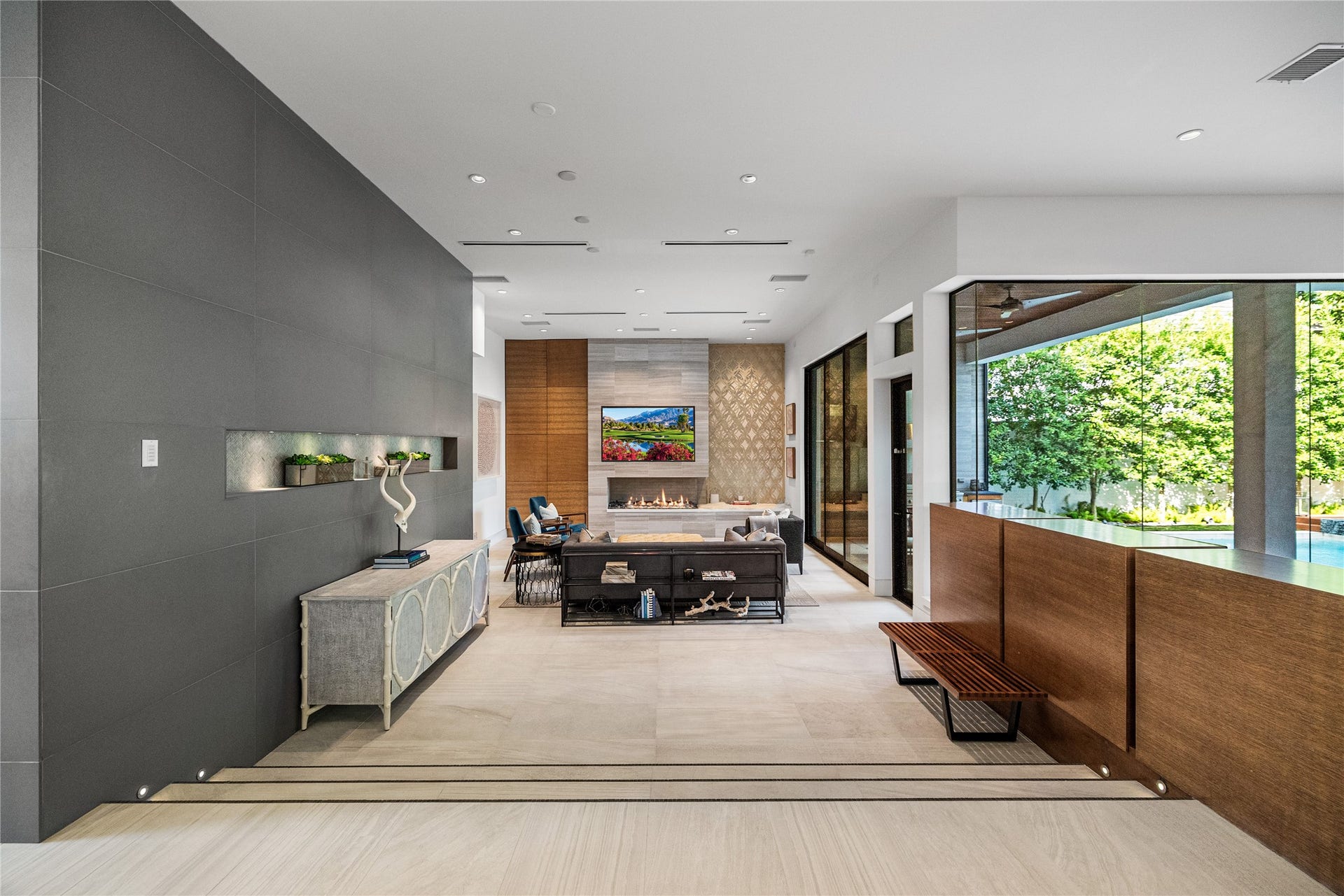 2608 Barbara Lane, Houston, TX 77005 Step down into a light-filled living room designed for both quiet evenings and grand entertaining, with a linear fireplace, a softly lit display niche, and walls of glass bringing the outdoors in.