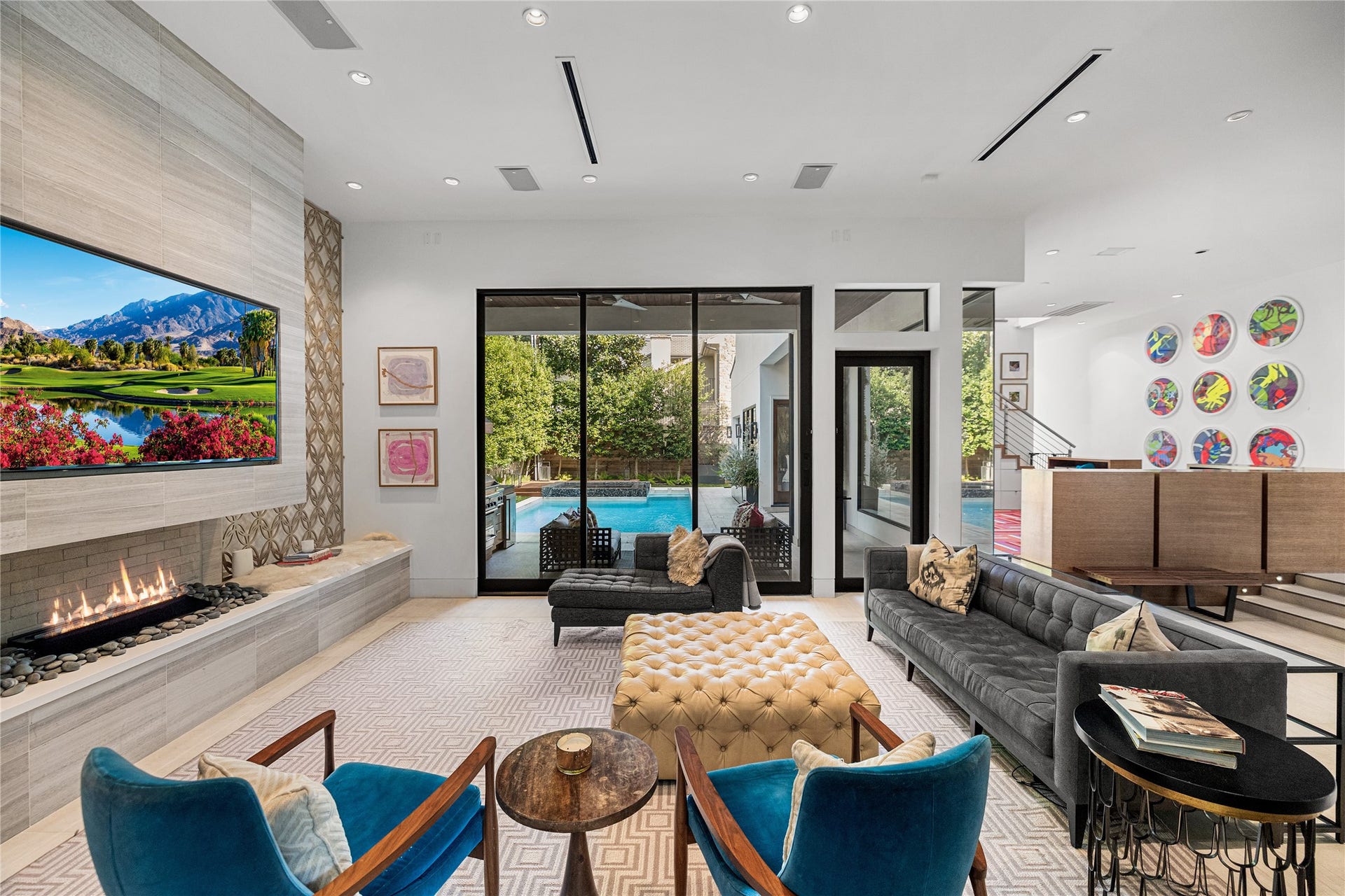 2608 Barbara Lane, Houston, TX 77005 From this angle, a long stone hearth, a linear gas fireplace, and steel-framed sliding glass doors open the living room to the covered patio and pool beyond. Beside the sliding doors, a separate door offers an easy path to the backyard.