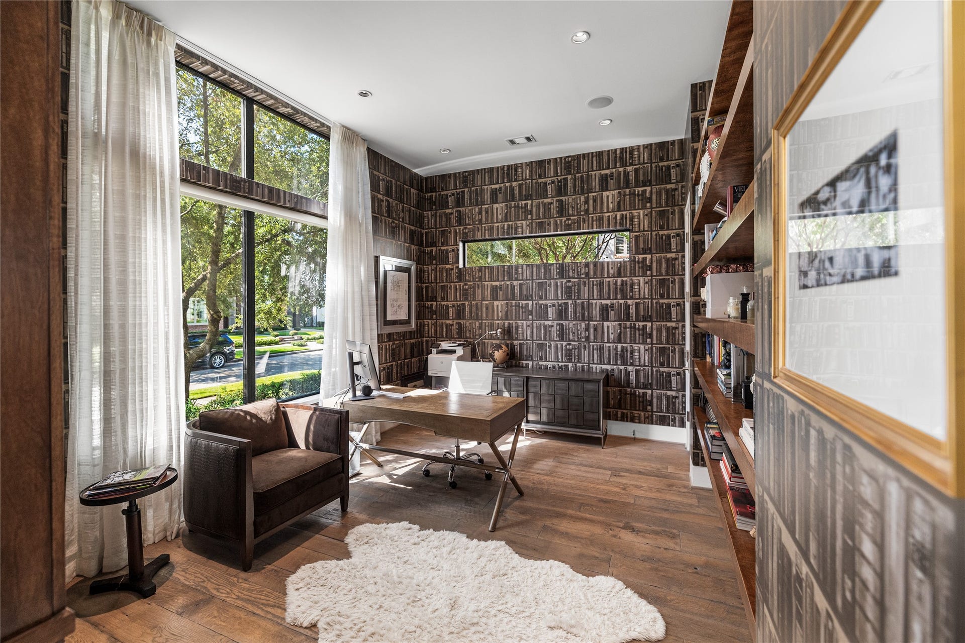 2608 Barbara Lane, Houston, TX 77005 To the left of the entry, this first-floor study is rich and tailored with walls of windows framing tree-lined views. Hardwood floors and generous open shelving showcases books and collectibles.