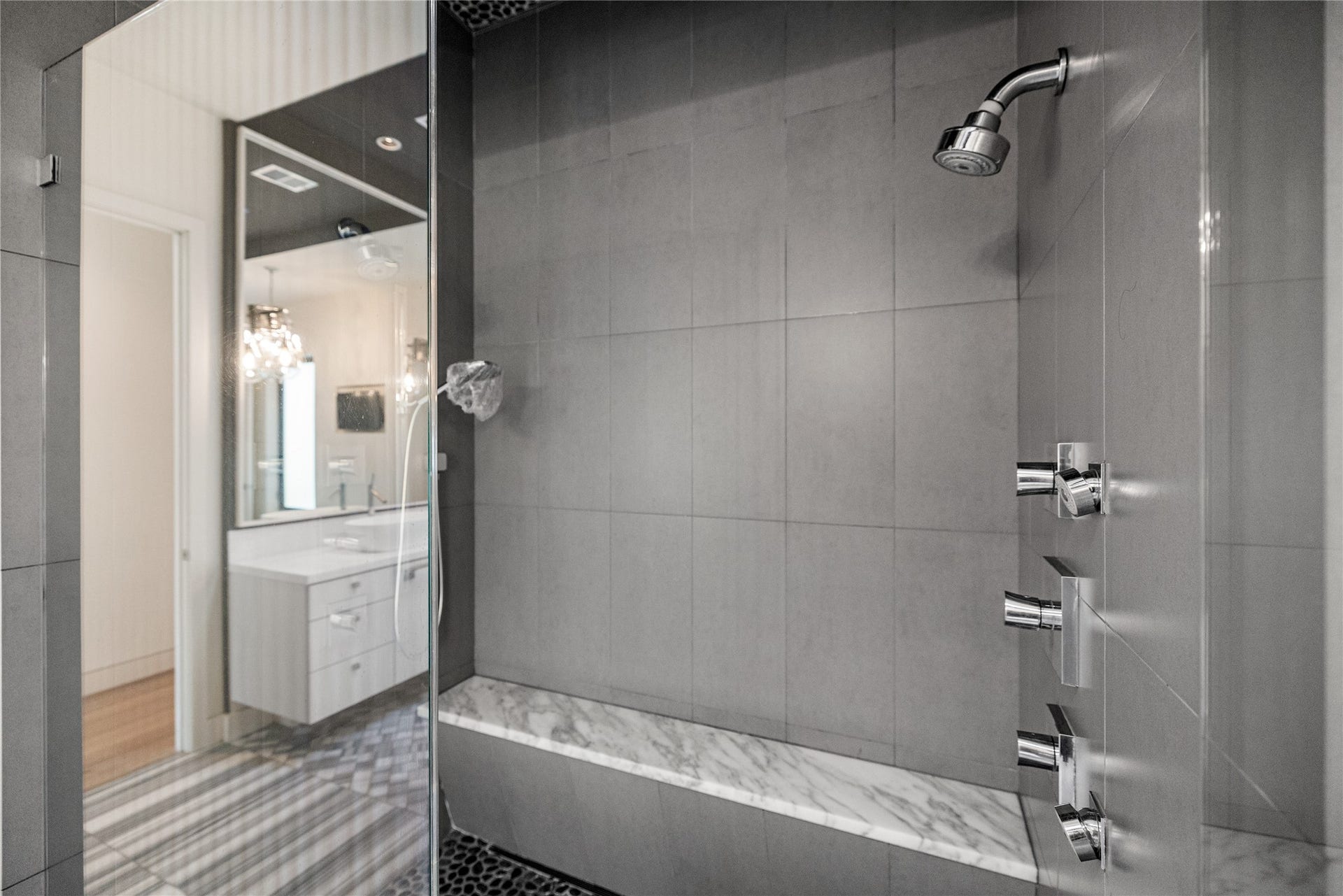 2608 Barbara Lane, Houston, TX 77005 Conceived as a private spa, the walk-in shower offers a rainfall showerhead, a wall-mounted showerhead, and body sprays. With double entry and a built-in marble bench, it invites a long, restorative soak in steam and water.