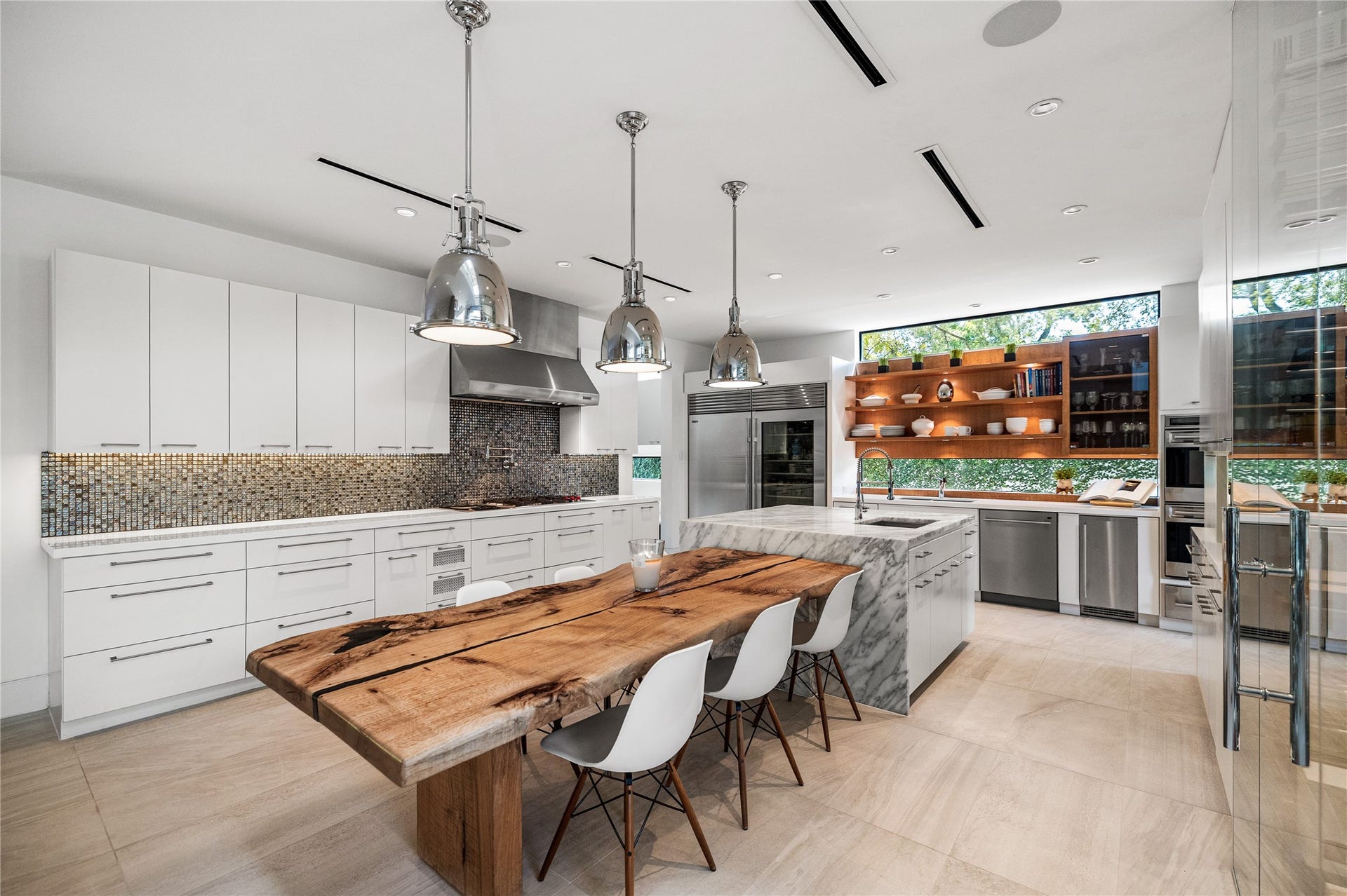 2608 Barbara Lane, Houston, TX 77005 Statement pendants and a wall of storage with clean linear hardware create a kitchen that feels both modern and enduring. The cooking wall adds a gas cook-top, built-in steamer, pot filler, and commercial-grade vent hood.