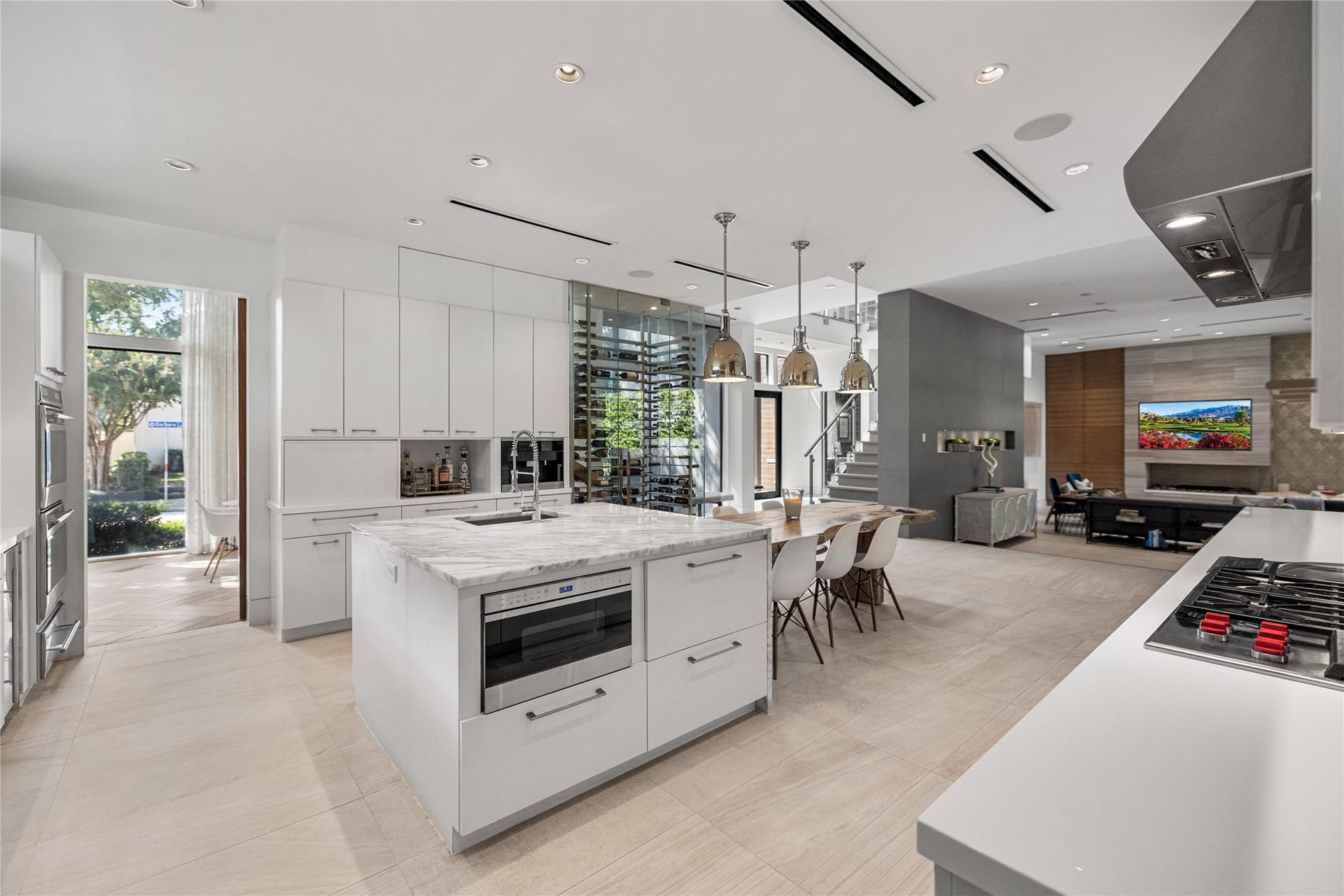 2608 Barbara Lane, Houston, TX 77005 At the heart of the home, the kitchen flows effortlessly between the formal dining room at the front of the residence and the inviting living room beyond, creating a natural sense of connection throughout the main living spaces.