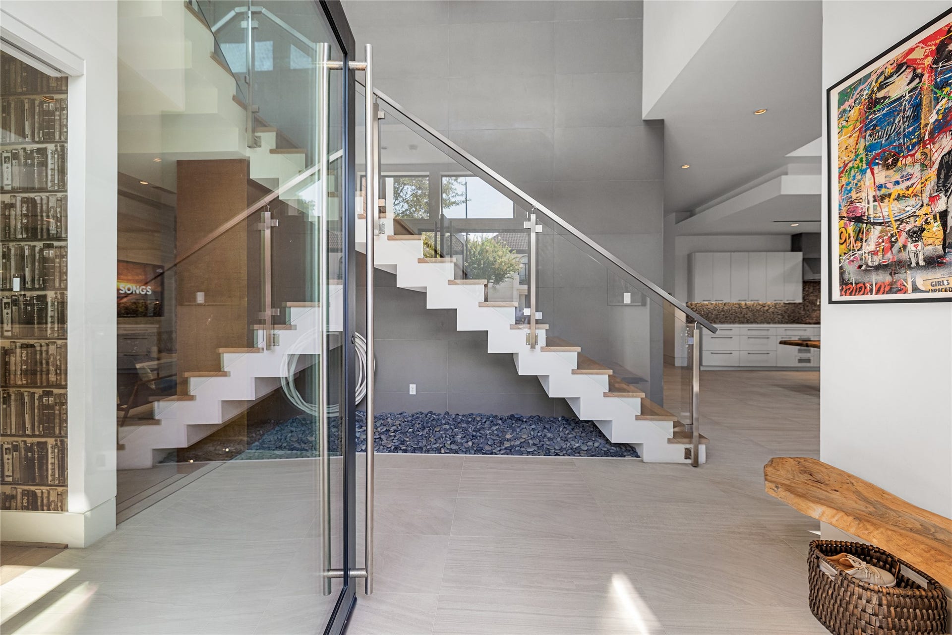2608 Barbara Lane, Houston, TX 77005 An oversized glass pivot door, both modern and timeless, opens to a sculptural staircase floating above a bed of river stone. This two-story light-filled foyer makes a quiet, confident first impression. Just to your left is your first-floor dedicated study/office (one of two offices in this home).