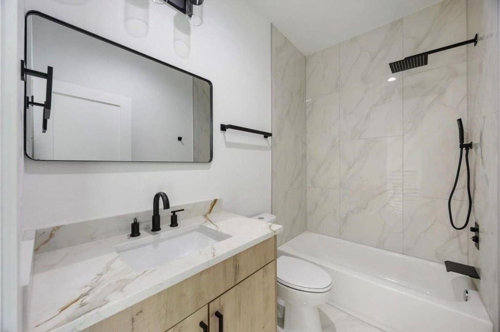 7920 Boy Street, #B, Houston, TX 77028 Modern bathroom featuring a spacious vanity, contemporary fixtures, and a bathtub with shower.