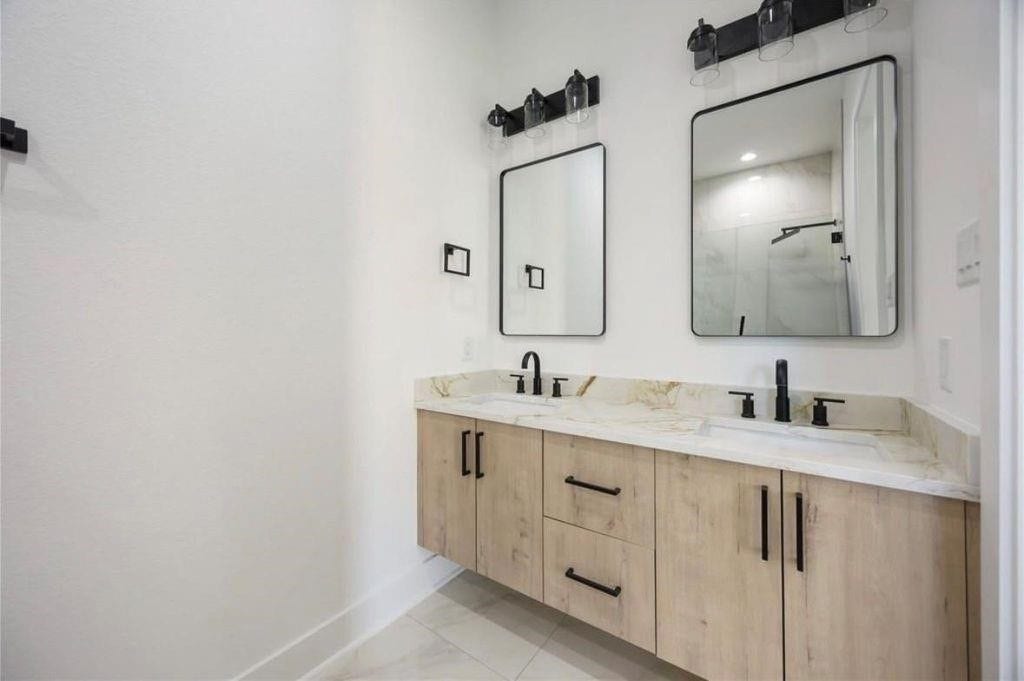 7920 Boy Street, #B, Houston, TX 77028 Beautifully designed bathroom with a double-sink vanity, ample cabinet storage, and modern mirrors.