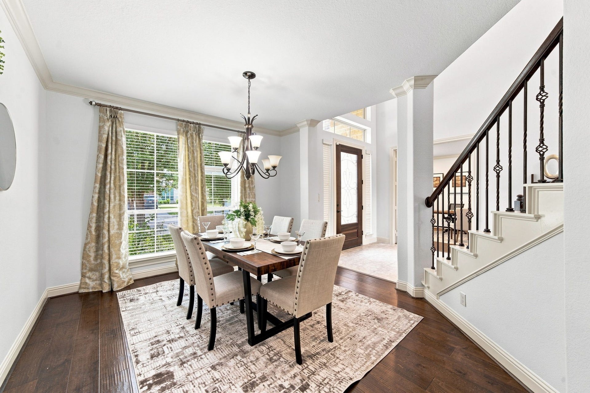Elegant dining space filled with natural sunlight and warm hardwood floors throughout.