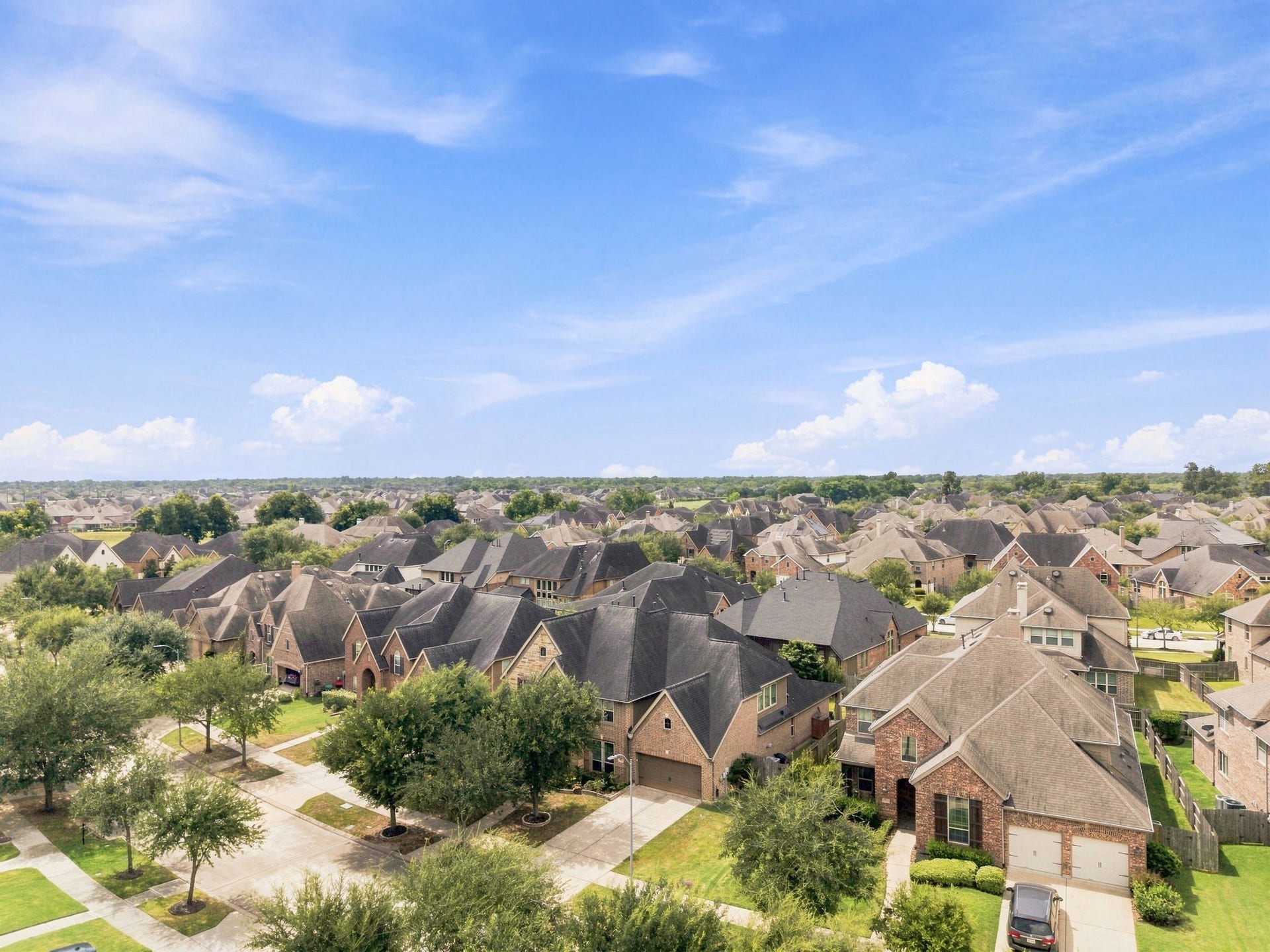 Aerial view of the home's rooftop within the Riverstone community, surrounded by tree-lined streets and neighborhood.