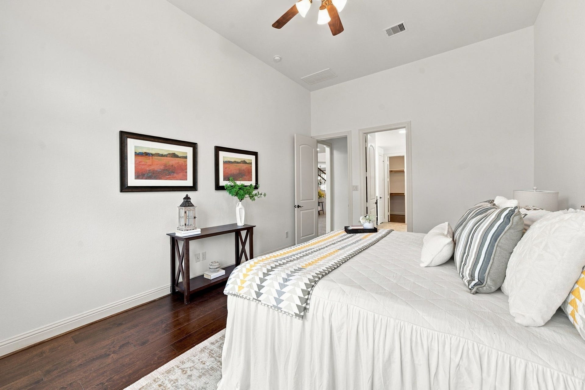 Spacious Bedroom with rich wood flooring rich hardwood floors and a large window filling the room with natural light.