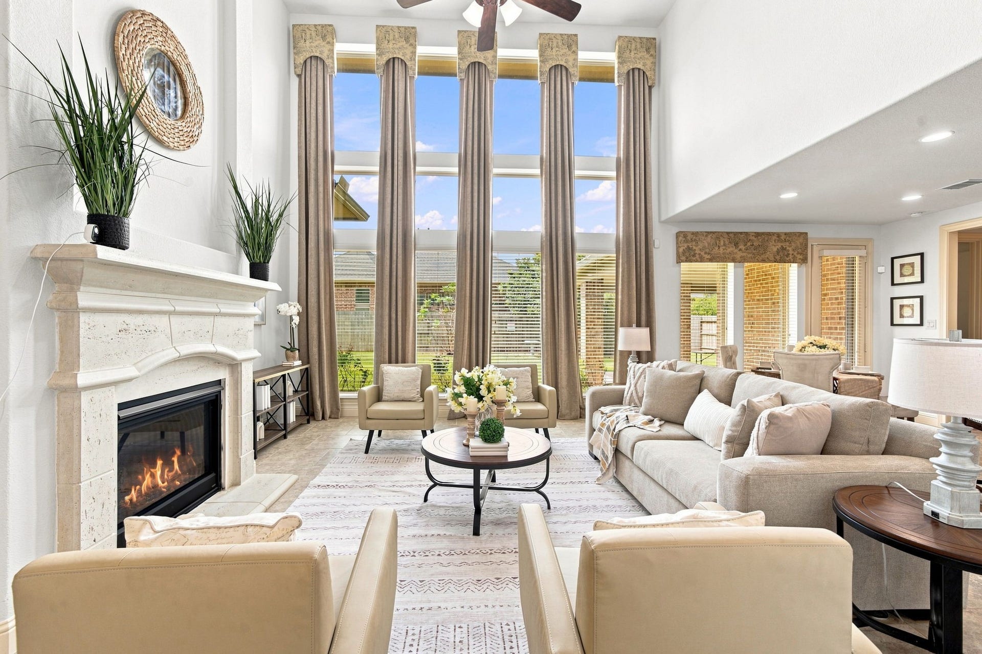 Light filled living room with expansive windows and a cozy fireplace, ideal for relaxing or entertaining