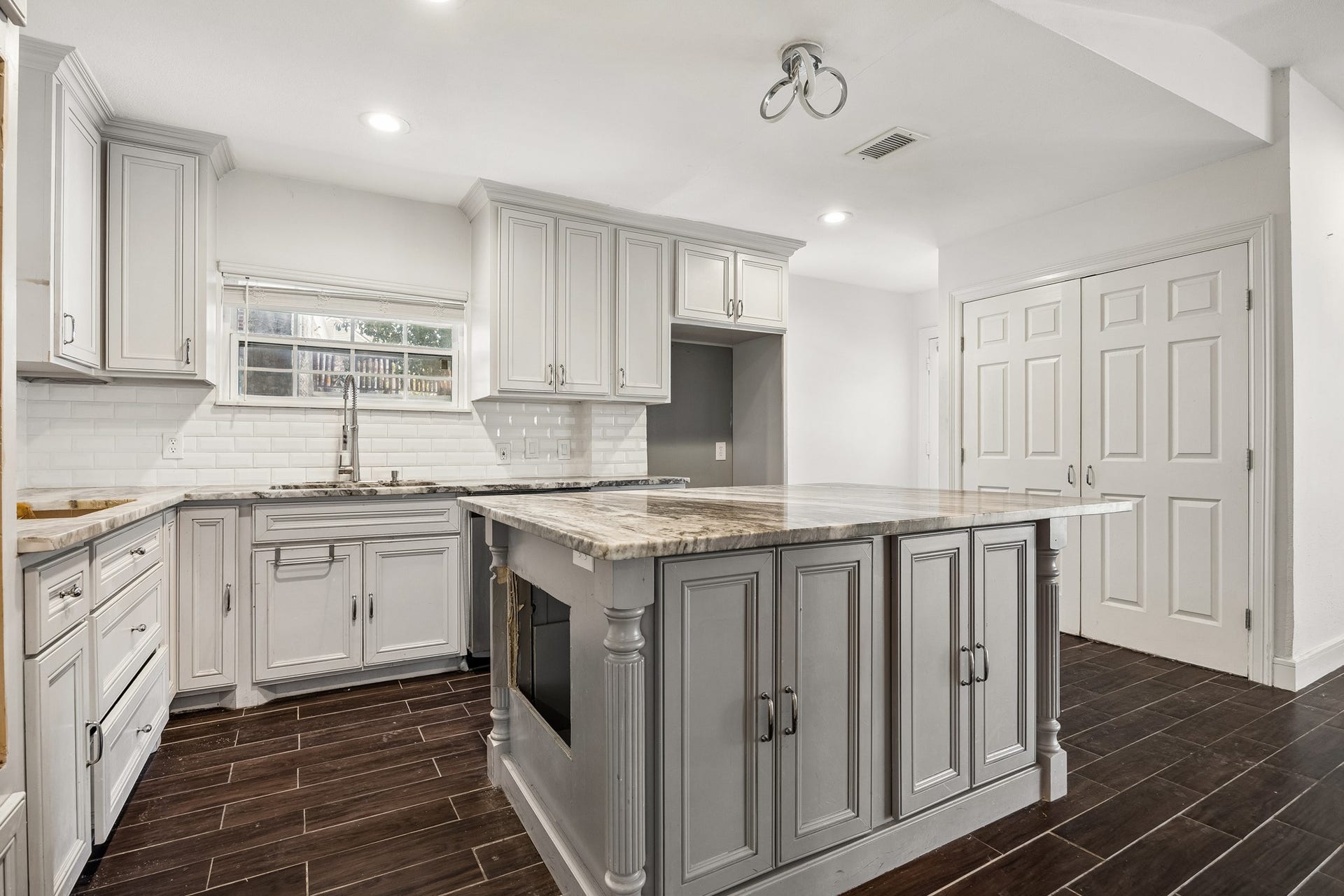 4431 N Roseneath Drive, Houston, TX 77021 Kitchen with island, subway tile backsplash and pantry.