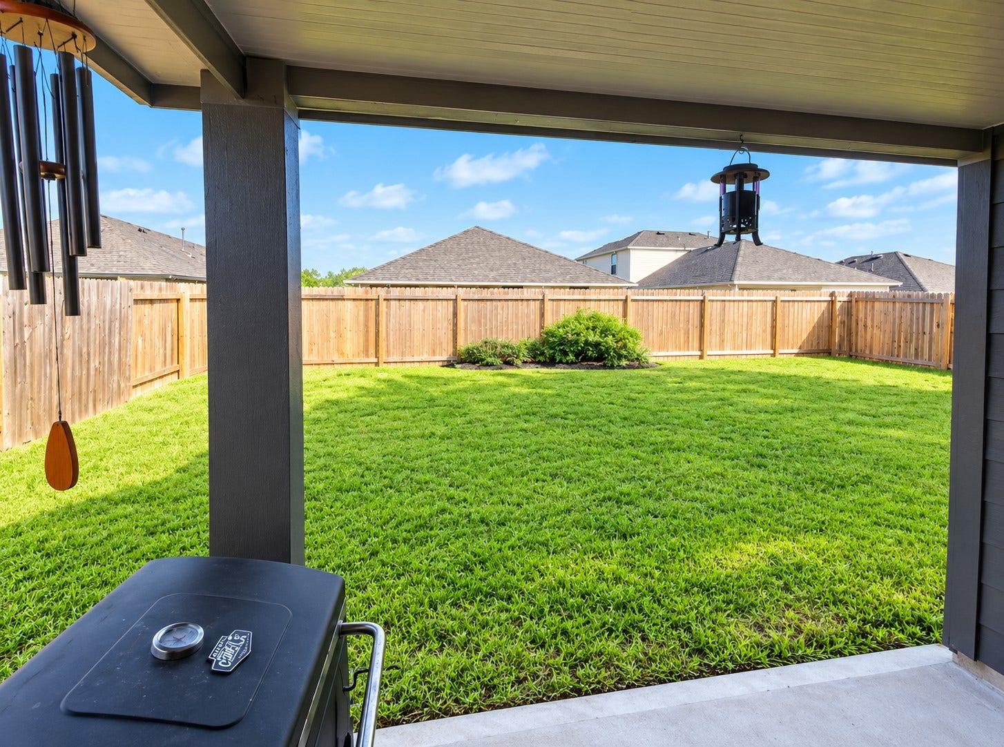 Enjoy outdoor living from the covered patio, offering a comfortable space for morning coffee, relaxing, or entertaining while overlooking the backyard.