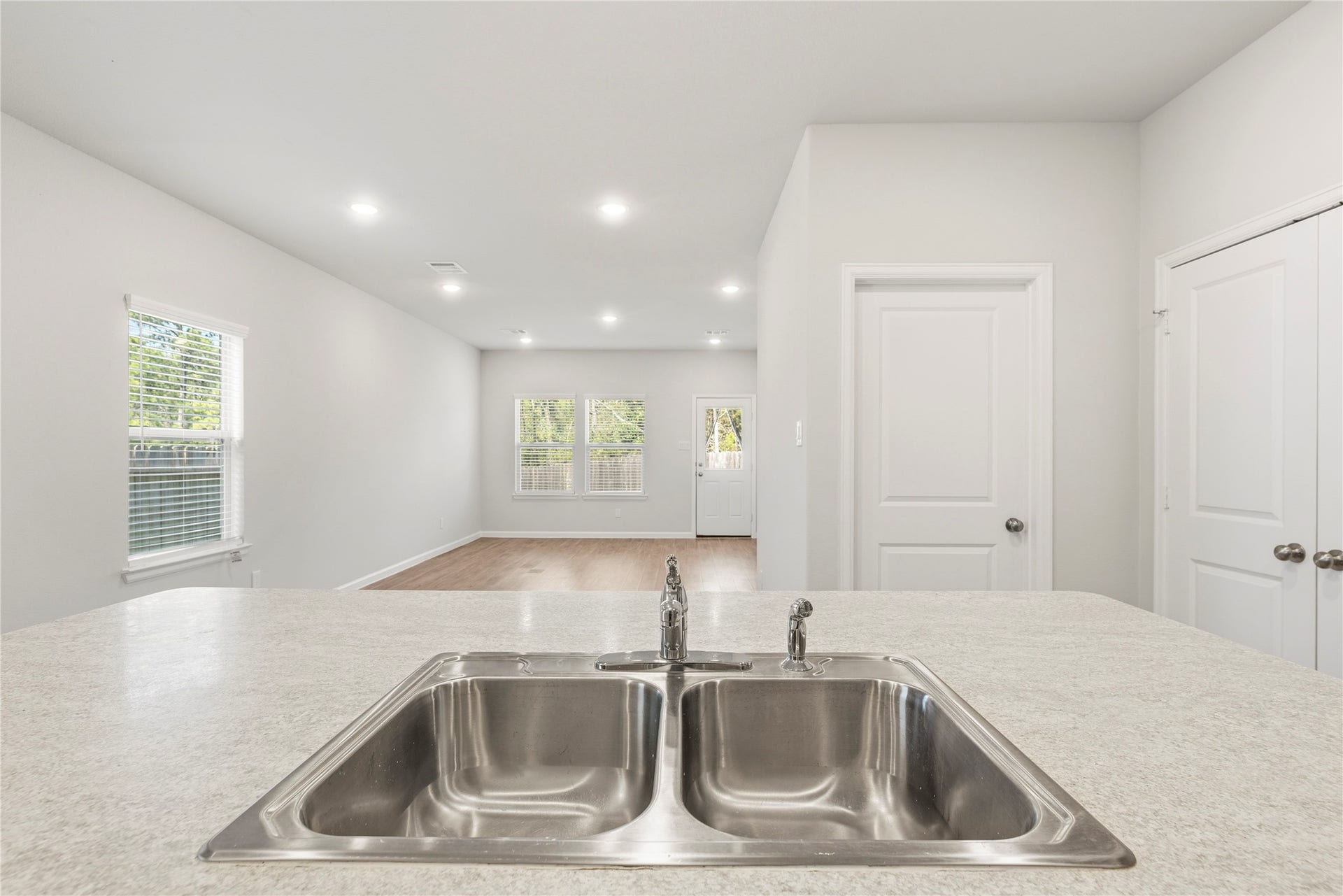 16493 Moss Lane, Porter, TX 77365 The view from the kitchen sink reaches across the living area to the rear windows and back doora pleasant outlook while handling everyday kitchen tasks.