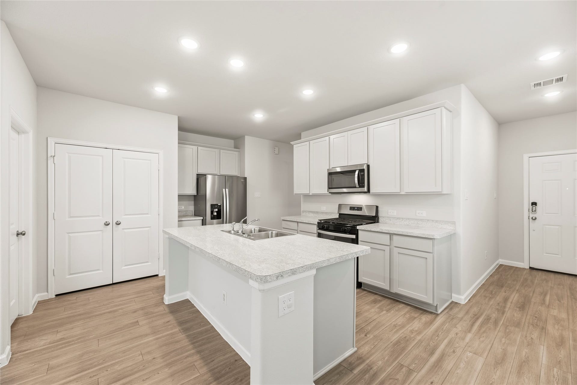 16493 Moss Lane, Porter, TX 77365 White cabinetry, stainless-steel appliances and an island create a bright, coordinated kitchen. The open layout keeps the cook connected to the rest of the room.
