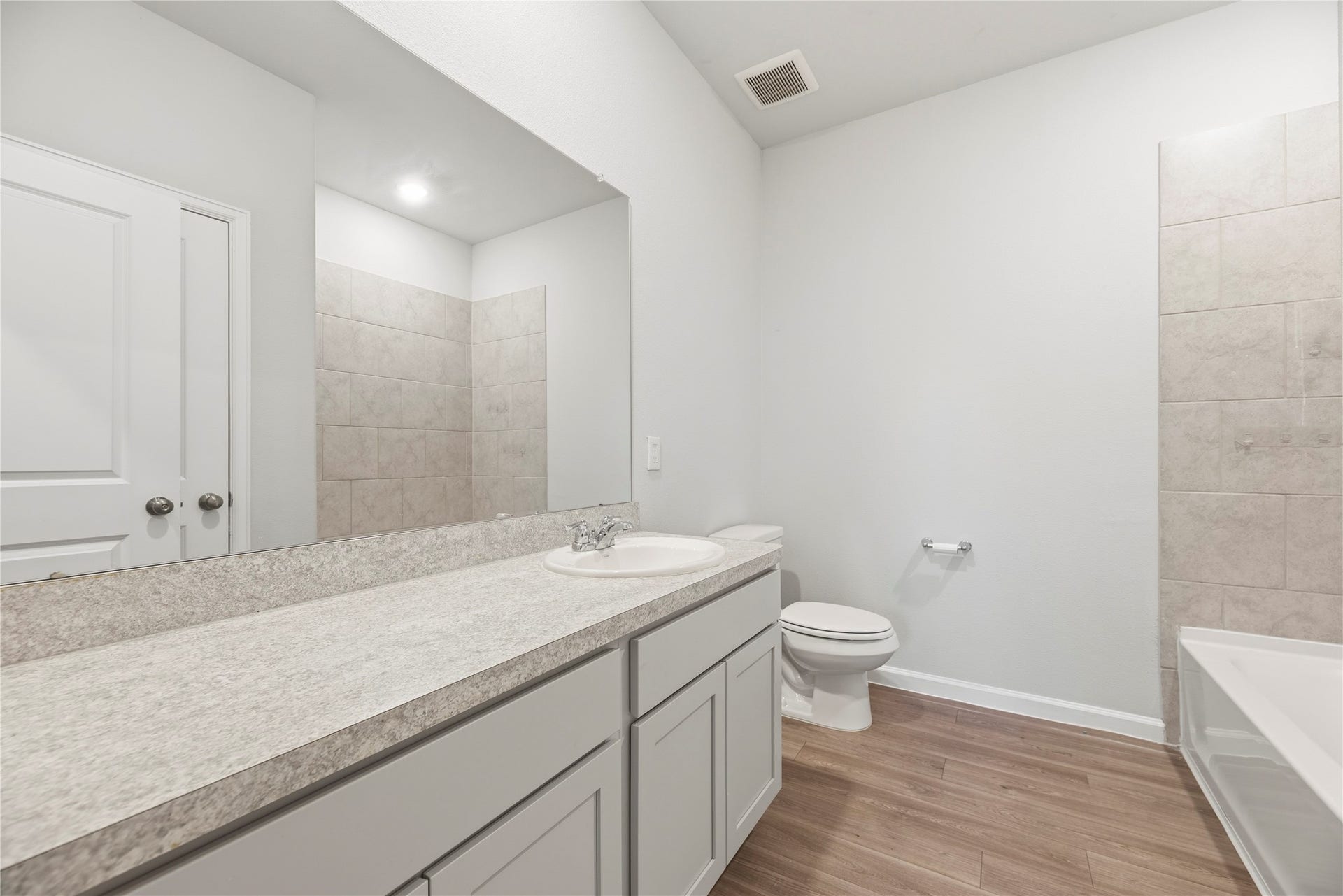 16493 Moss Lane, Porter, TX 77365 A long vanity offers room to spread out during the morning routine, with cabinet storage below and a tub with a tile surround alongside.