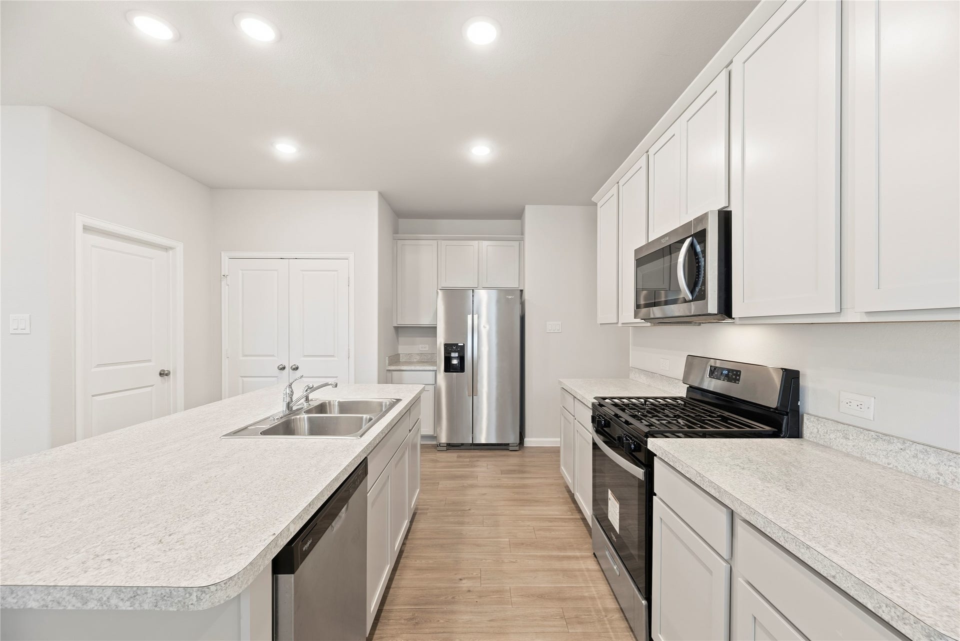 16493 Moss Lane, Porter, TX 77365 An efficient kitchen layout places the range, microwave and refrigerator around the island, with cabinet storage above and below the counters.