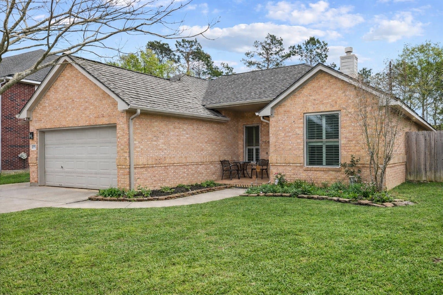 Charming single-story brick home with a 3-car garage and a welcoming front porch.