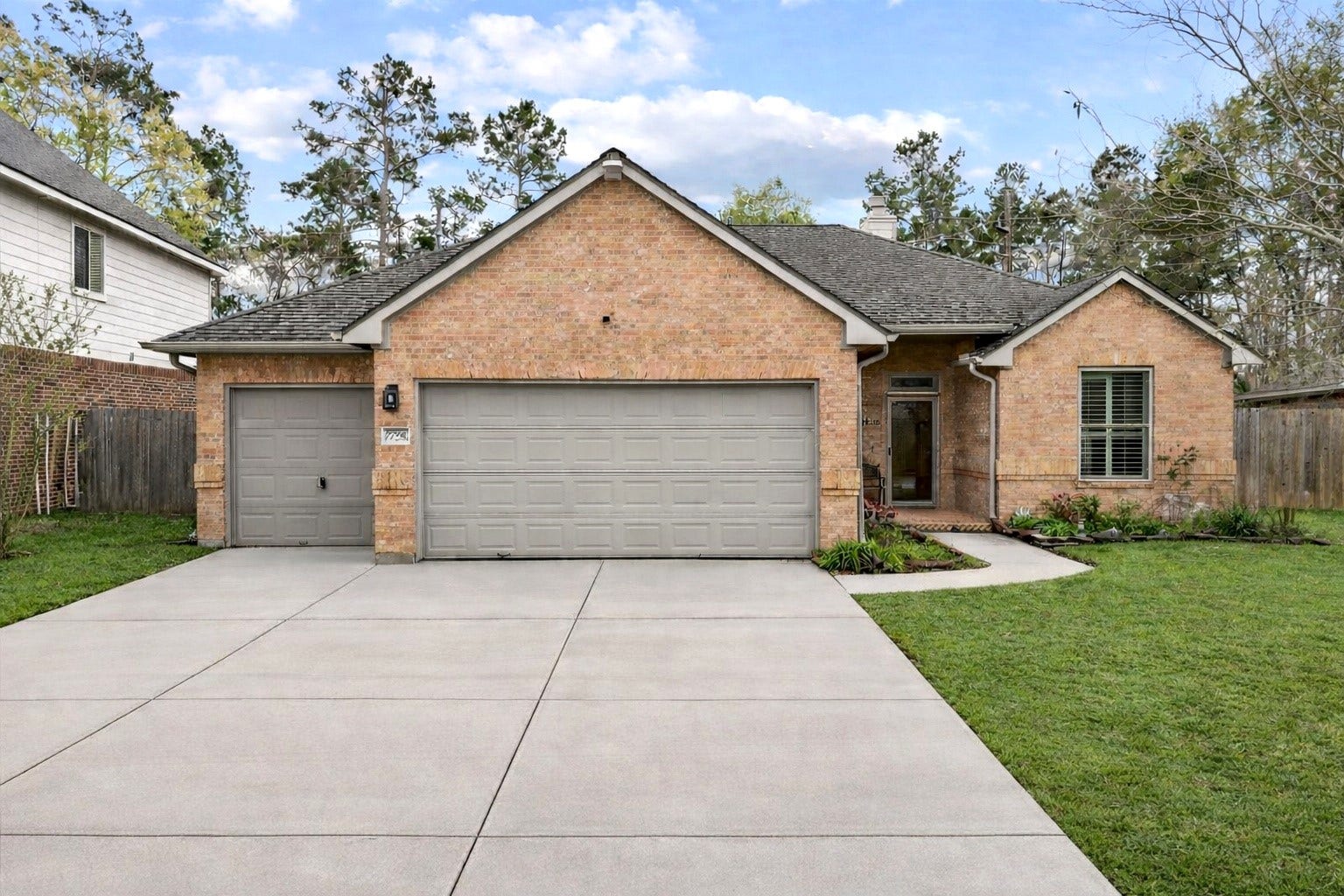 Discover this charming single-story brick home, featuring a spacious 3-car garage and a beautifully maintained front lawn. Perfect for those seeking a cozy suburban retreat.Driveway was edited with Ai.