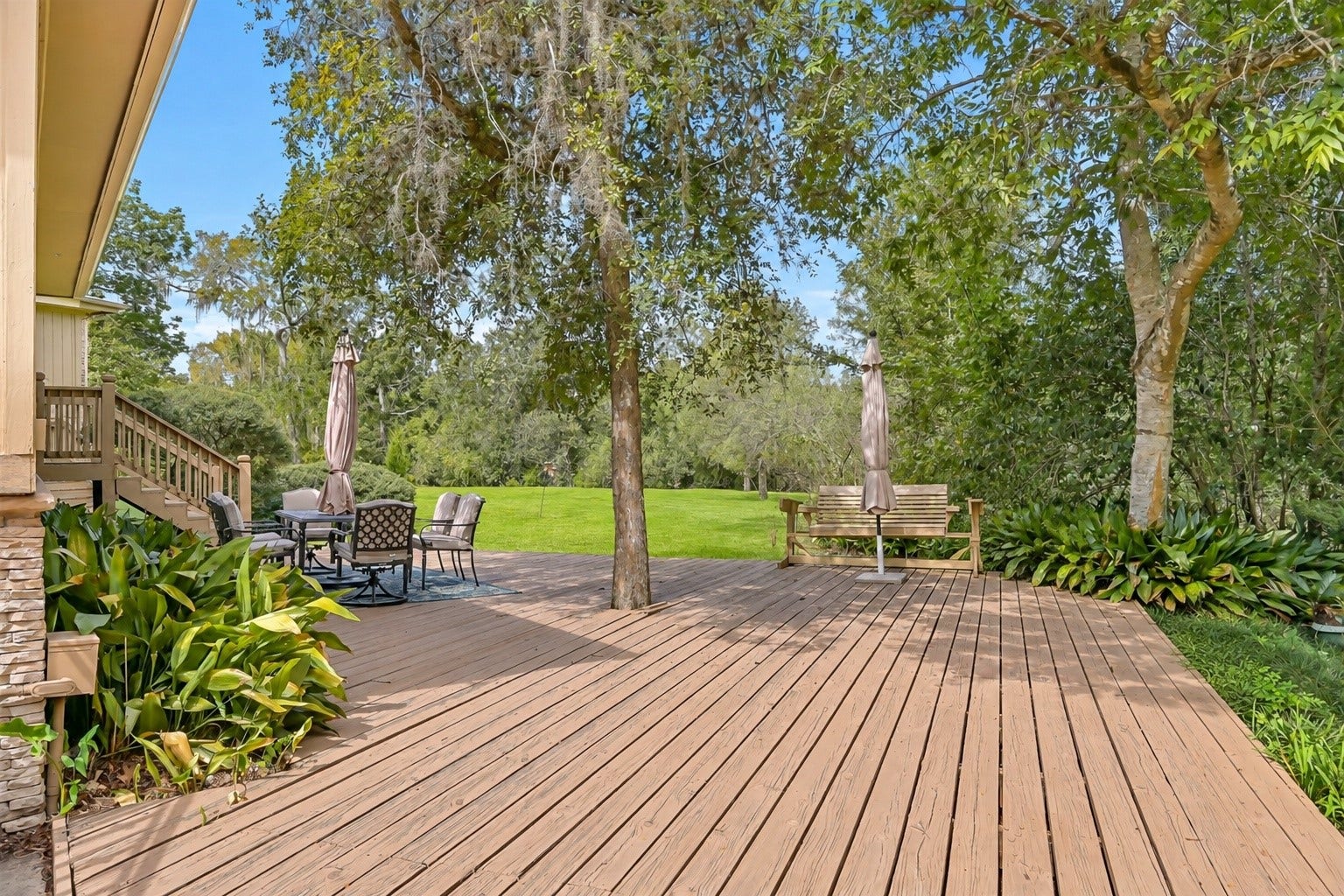 300 Courtlandt Place, Friendswood, TX 77546 An expansive wooden deck stretches across the rear of the home, providing generous space for outdoor dining, seating & entertaining. Surrounded by mature shade trees, this inviting outdoor area overlooks the sprawling backyard, with plenty of room to enjoy the property's natural setting.