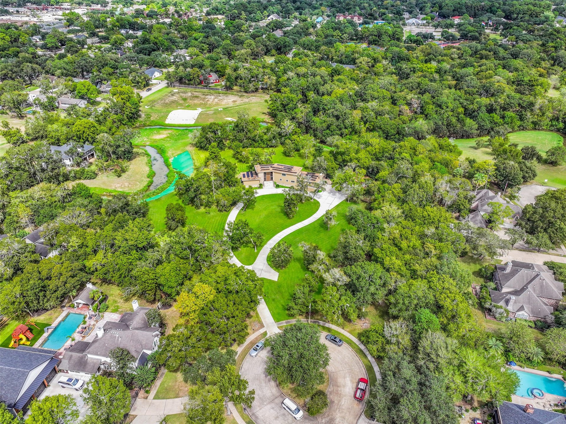 300 Courtlandt Place, Friendswood, TX 77546 An elevated perspective showcases the home's remarkable setting, with expansive grassy areas, towering shade trees & Cowart Creek winding through portions of the acreage. Enjoy the privacy of this tucked-away property while remaining conveniently close to central Friendswood amenities.