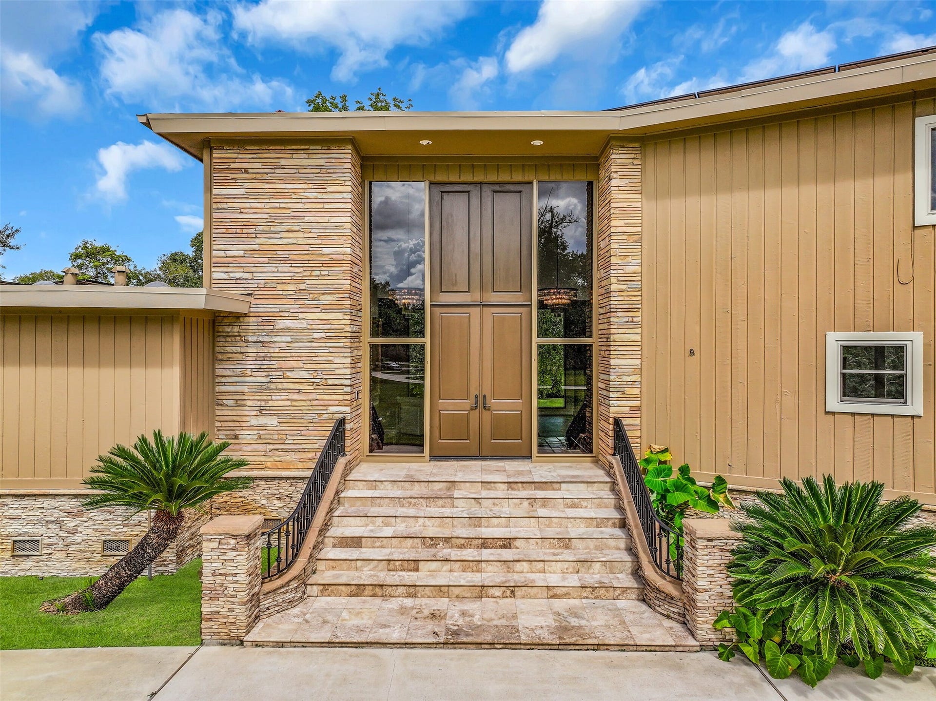 300 Courtlandt Place, Friendswood, TX 77546 A closer look at the impressive front entrance reveals oversized double doors framed by full-height glass sidelights. The dramatic architectural details continue inside, where a soaring 17' entry ceiling, two grand chandeliers & open-riser staircase create a striking first impression.
