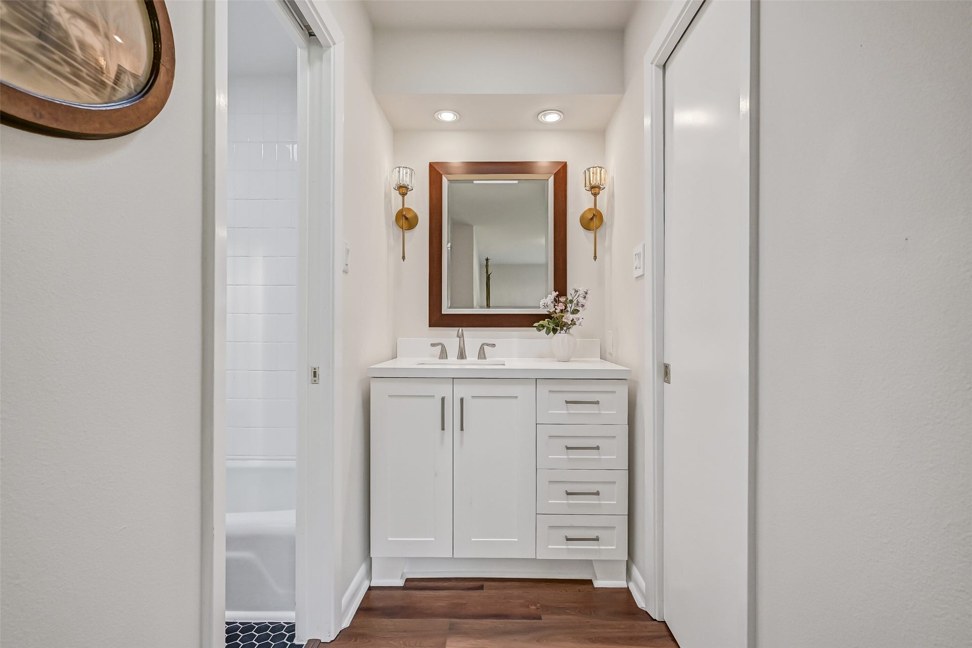 300 Courtlandt Place, Friendswood, TX 77546 The second private vanity area features updated white cabinetry, a rectangular framed mirror, decorative gold sconces & generous drawer storage. Located just outside the shared bathing area, this thoughtfully arranged Jack & Jill bathroom provides separate grooming spaces for the adjoining bedrooms.