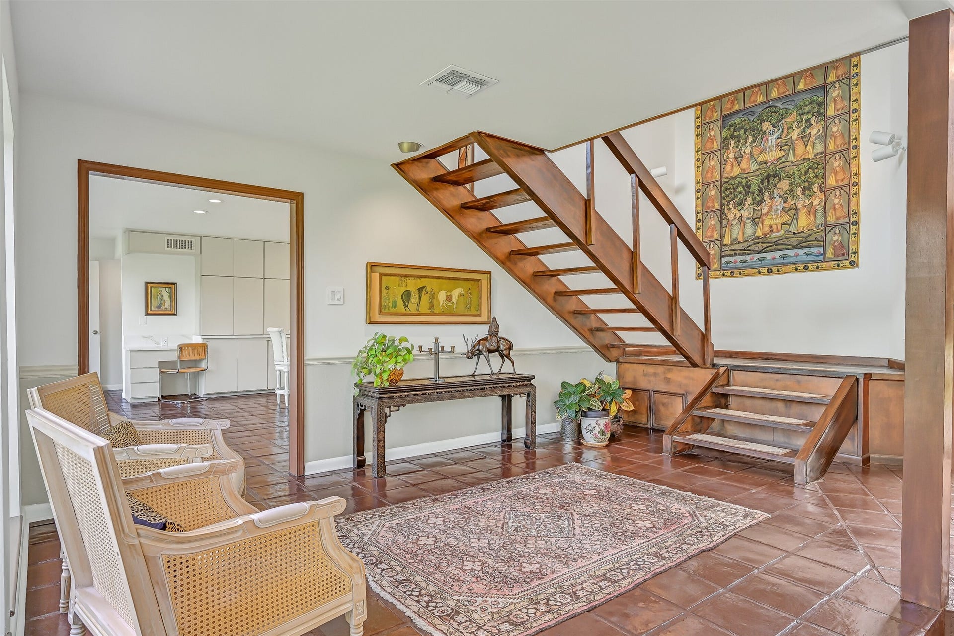 300 Courtlandt Place, Friendswood, TX 77546 The open-riser wooden staircase adds architectural character to this spacious entry hall, where rich wood accents & tile flooring reflect the home's distinctive design. Just beyond the wide doorway, the beautifully renovated kitchen awaits, featuring extensive cabinetry & an oversized island.